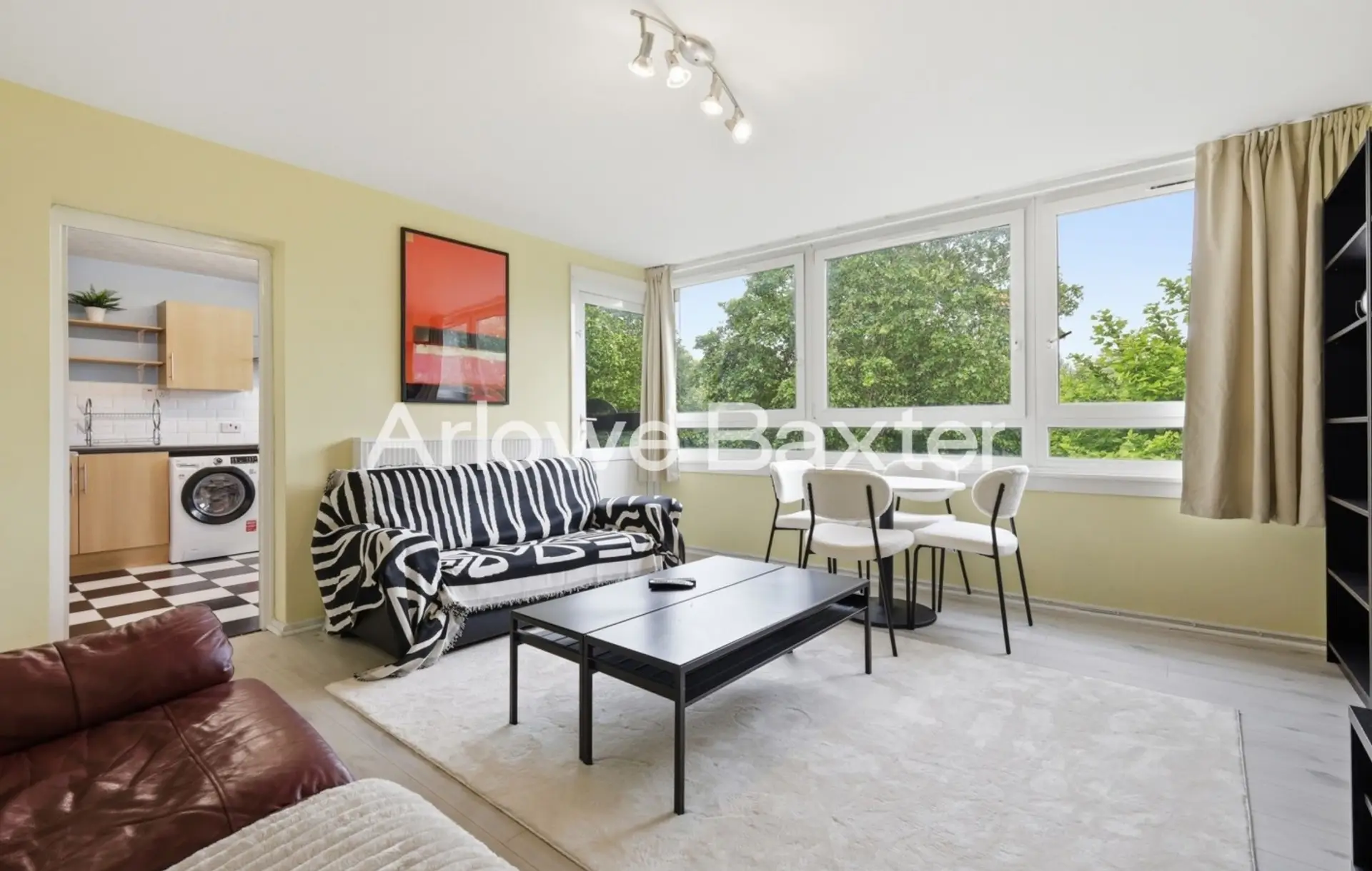 Spacious open-plan living and dining area with large windows that fill the space with natural light, creating a warm and welcoming atmosphere.