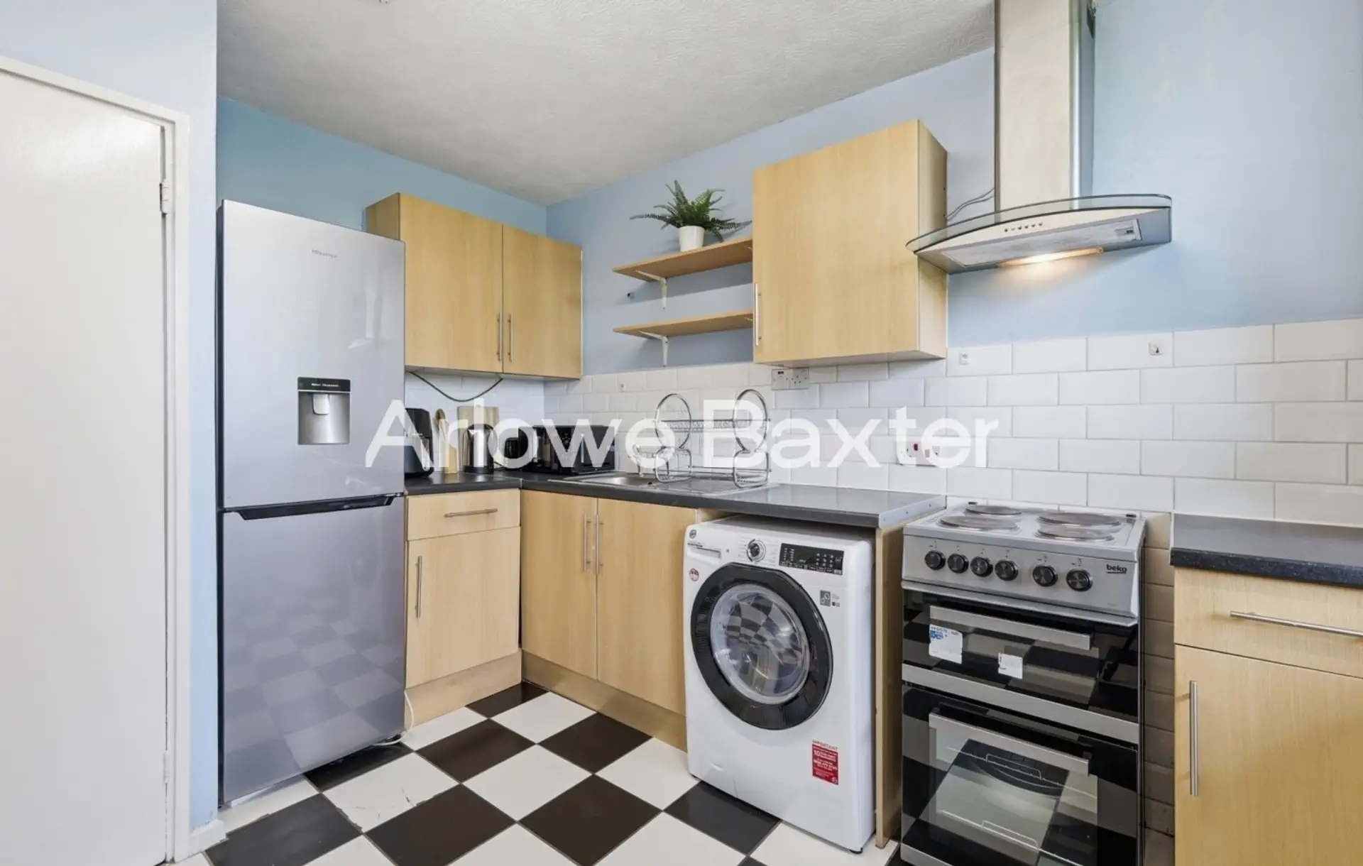 Compact and functional kitchen featuring a full-size refrigerator, oven, stovetop, washing machine, and all the essentials for a comfortable stay.