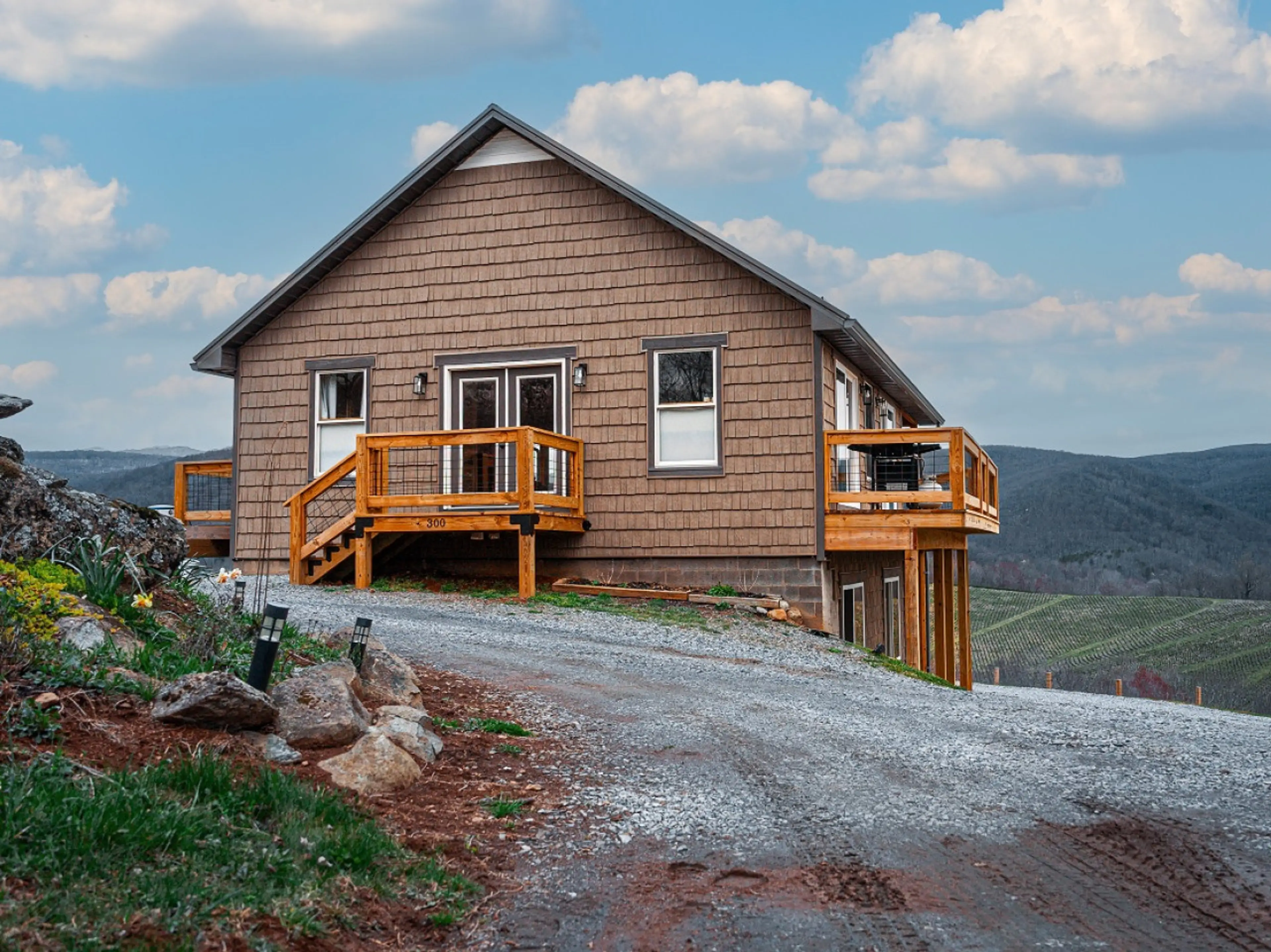 Main entrance to cabin showing decks and mountains behind it
