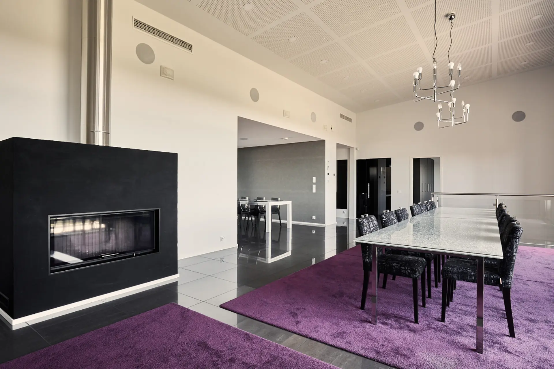 Elegant dining area featuring a sleek modern fireplace and high ceilings.