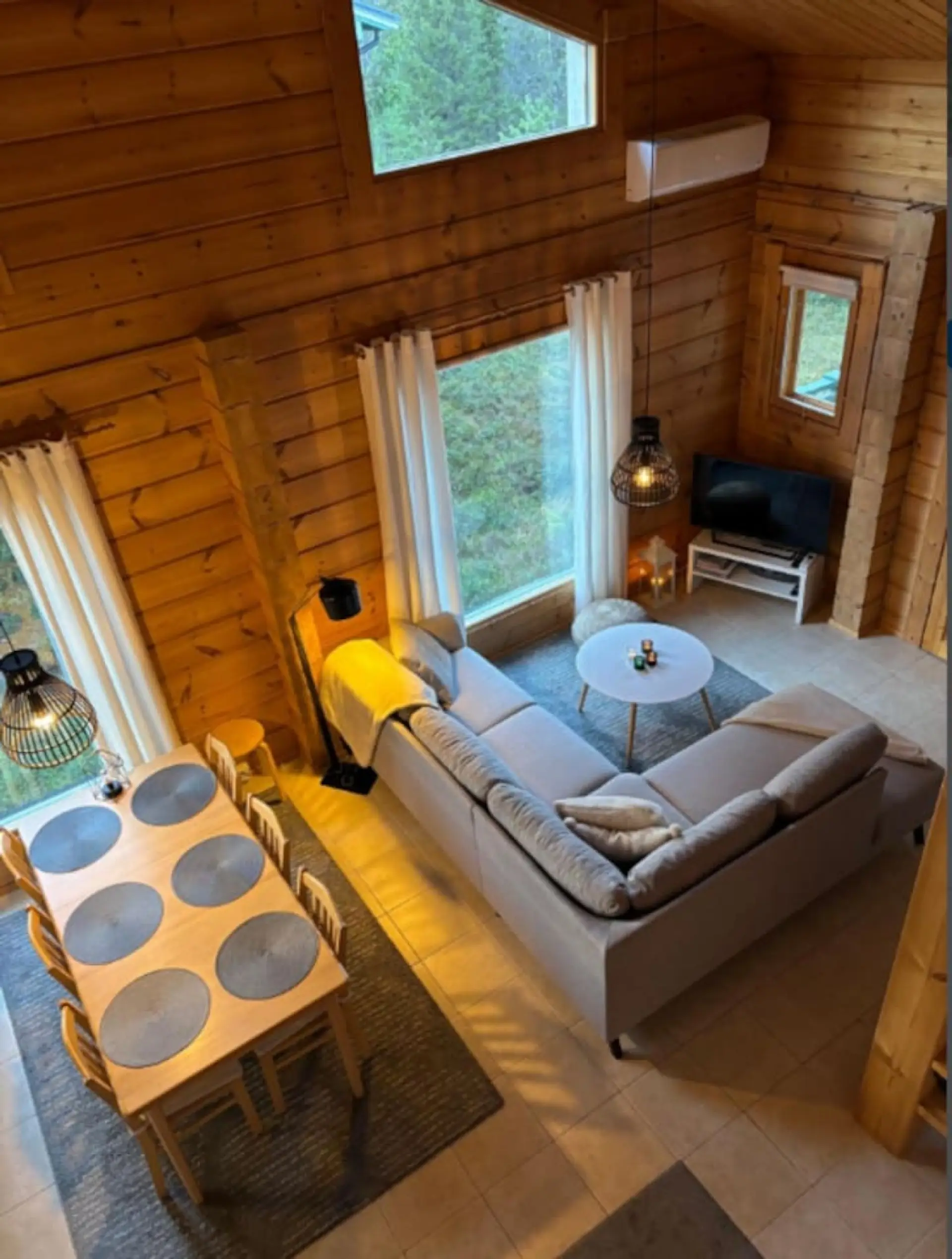 Bright living room with sofa seating, coffee tables and large windows.