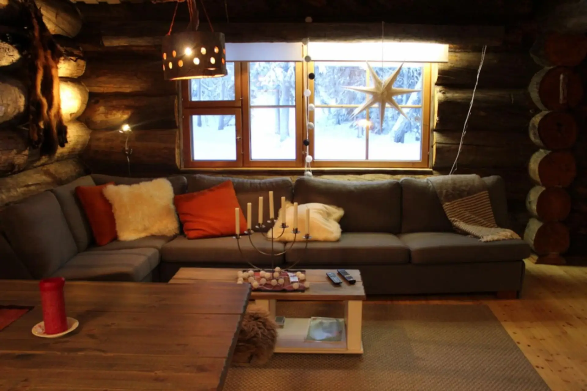 Cosy living room with a large corner sofa and forest views from the windows.