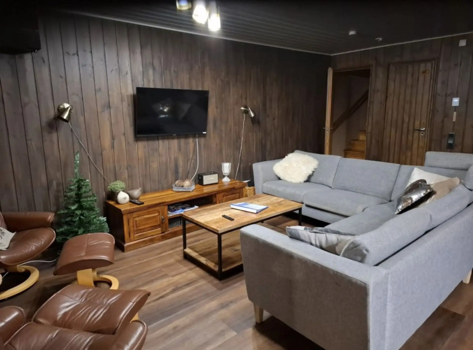 Living area with a spacious corner sofa, coffee table and wall-mounted smart TV.