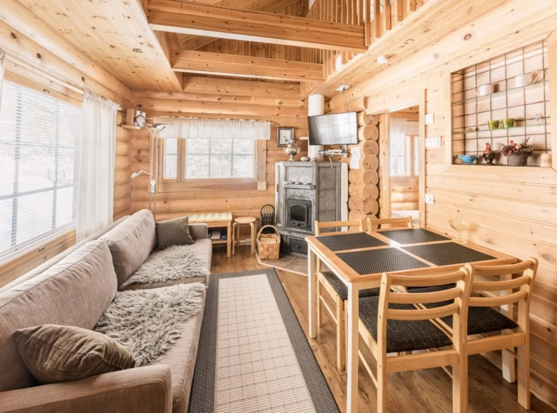 Open-plan living and dining area with a fireplace, a spacious corner sofa and a dining table with chairs.