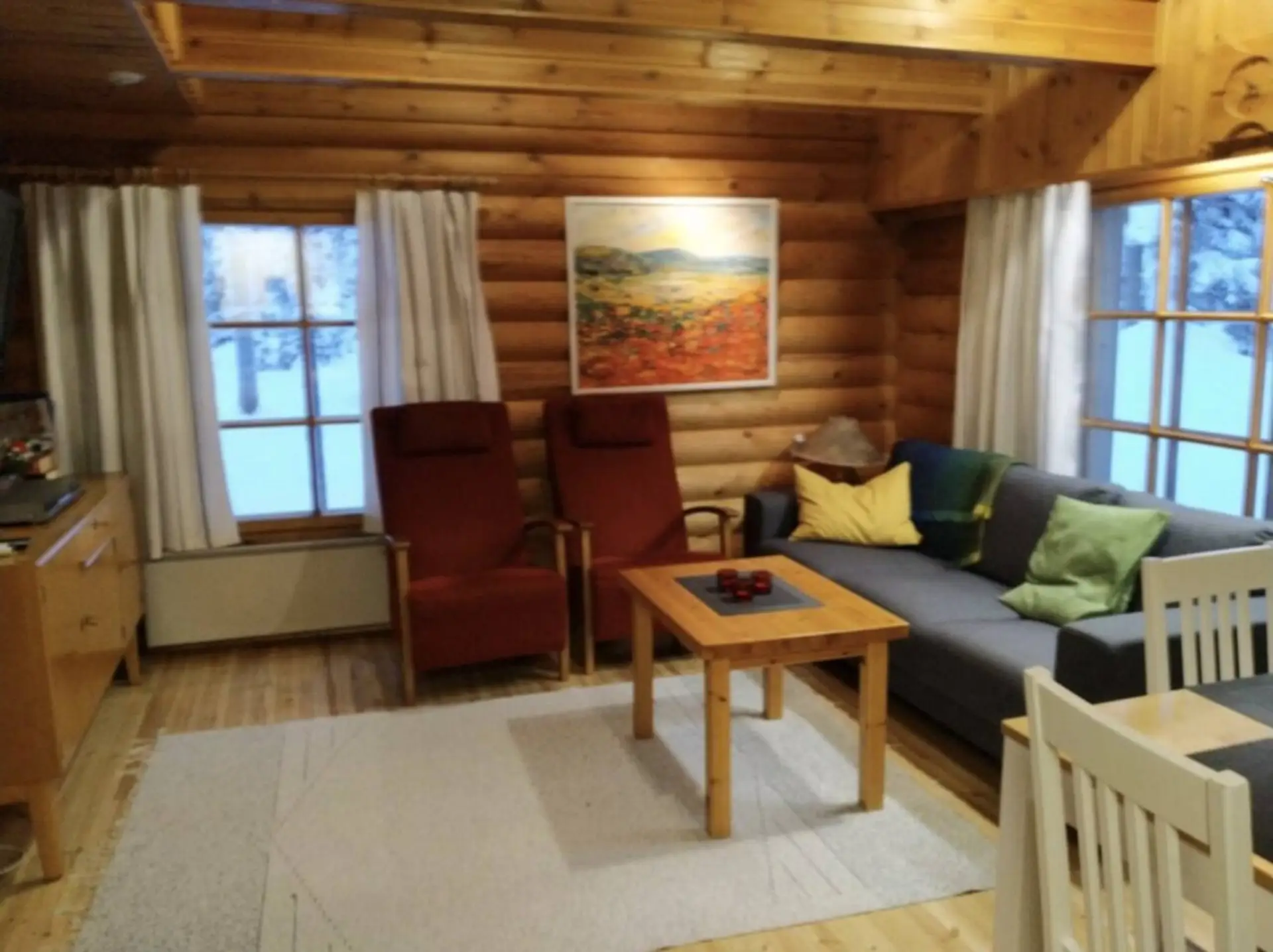 Cosy living room with a corner sofa, two armchairs and a wooden coffee table.