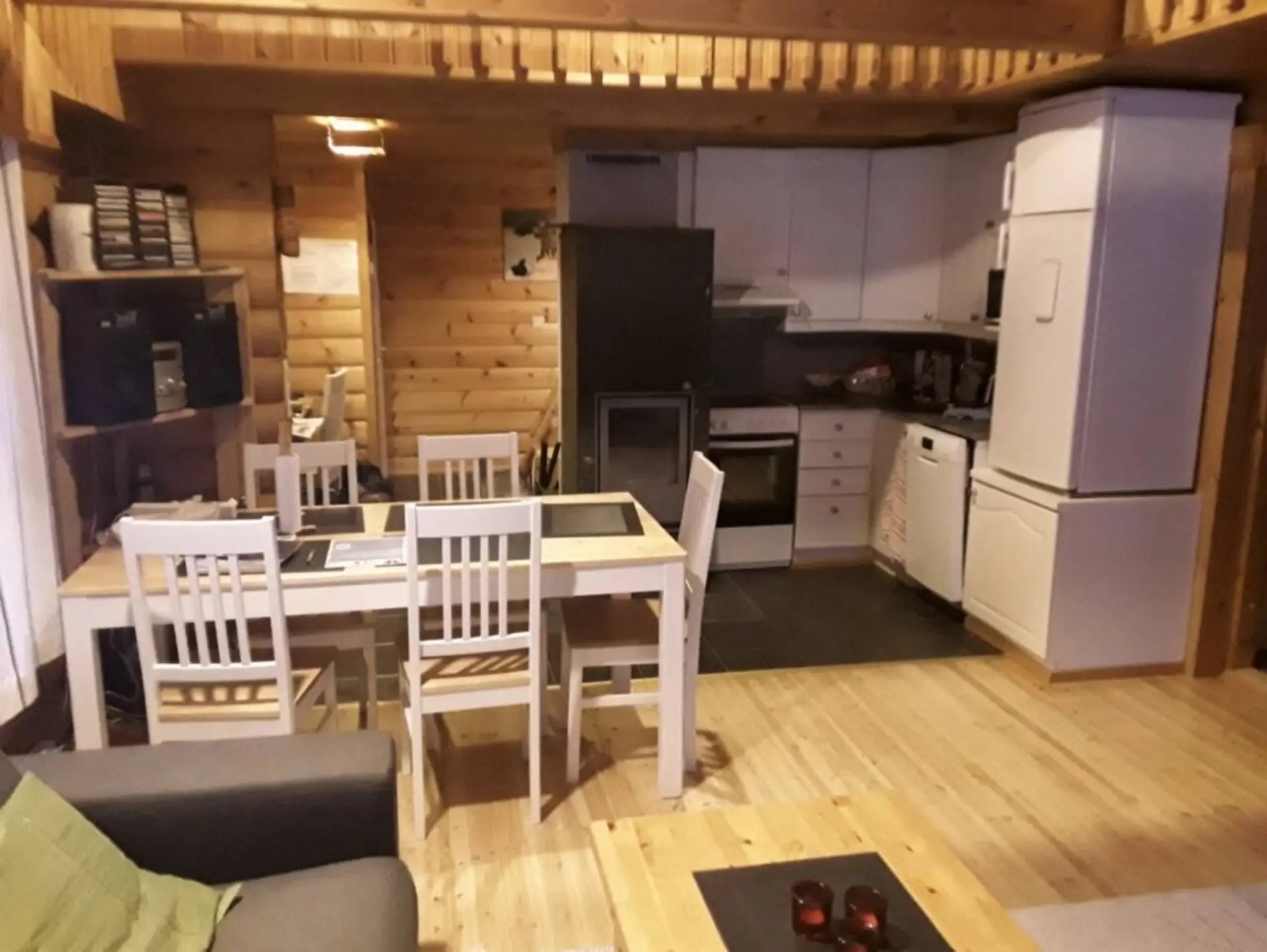 Open-plan kitchen and dining area with a dining table for six, a stove and a refrigerator.