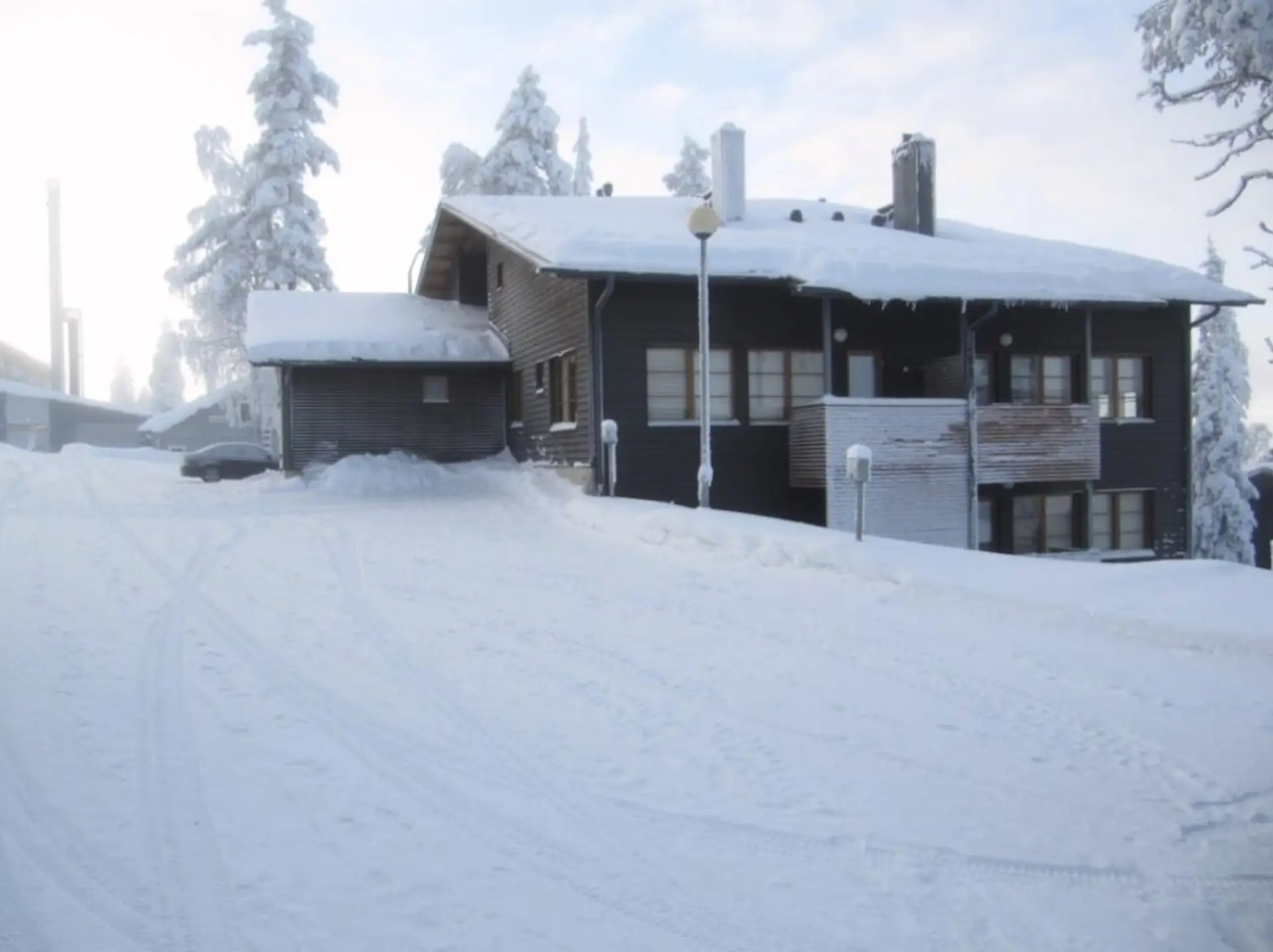 Exterior view of the apartment building and outdoor storage on a snowy winter day.