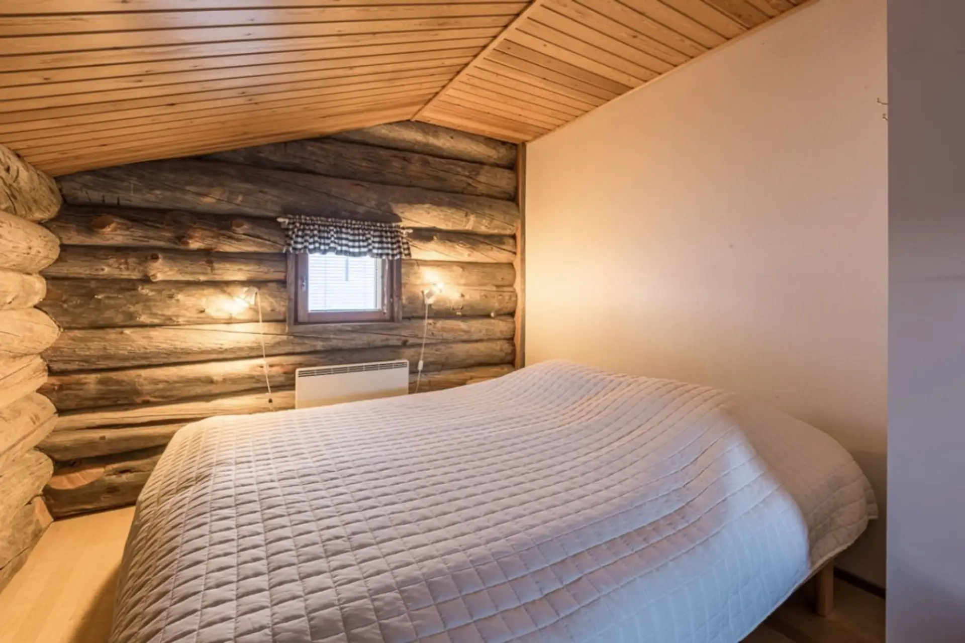 Loft sleeping area with a wide bed against the log wall.