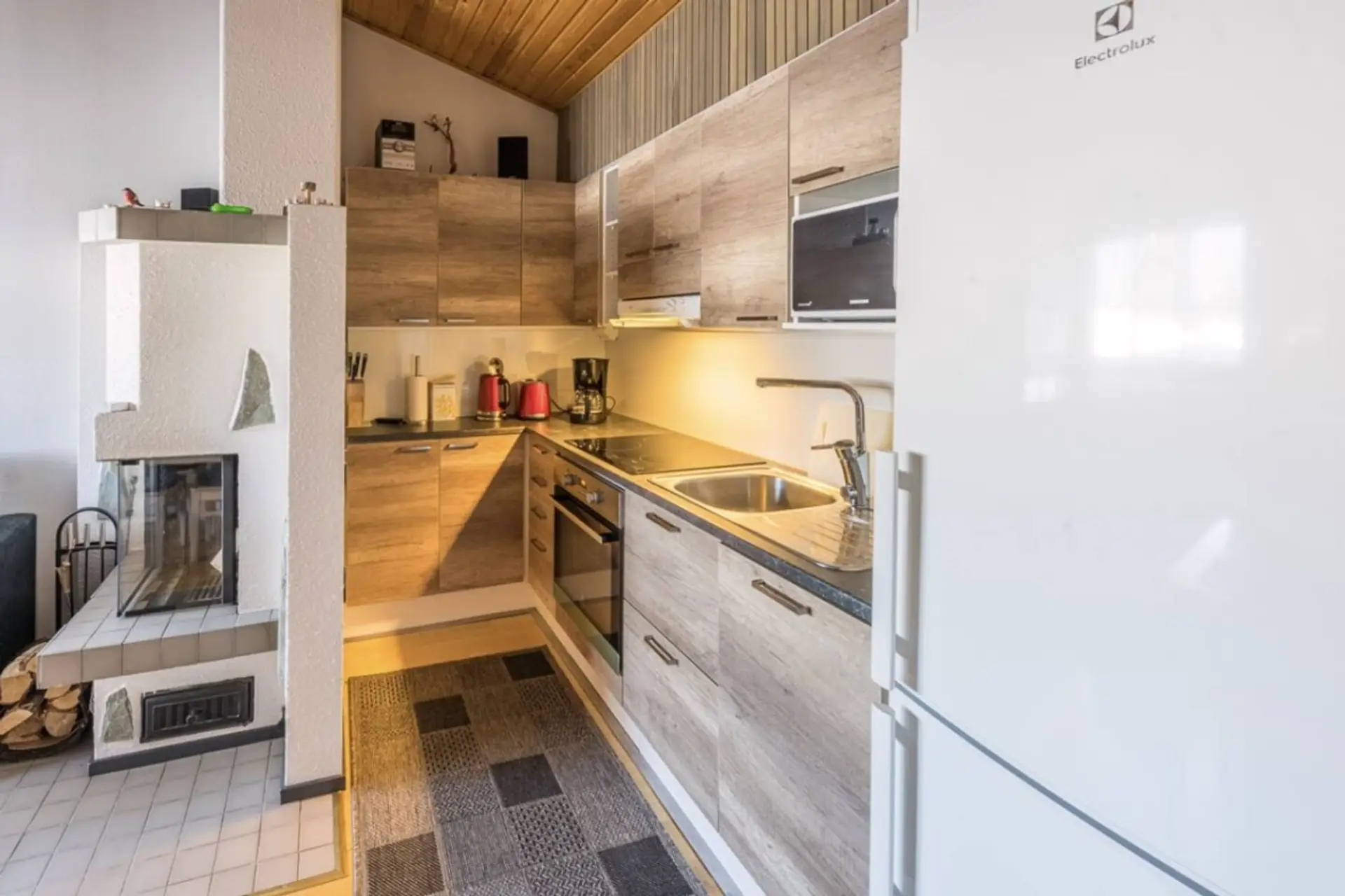 Fully equipped kitchen with an oven, stove, microwave, coffee maker and a fridge-freezer.