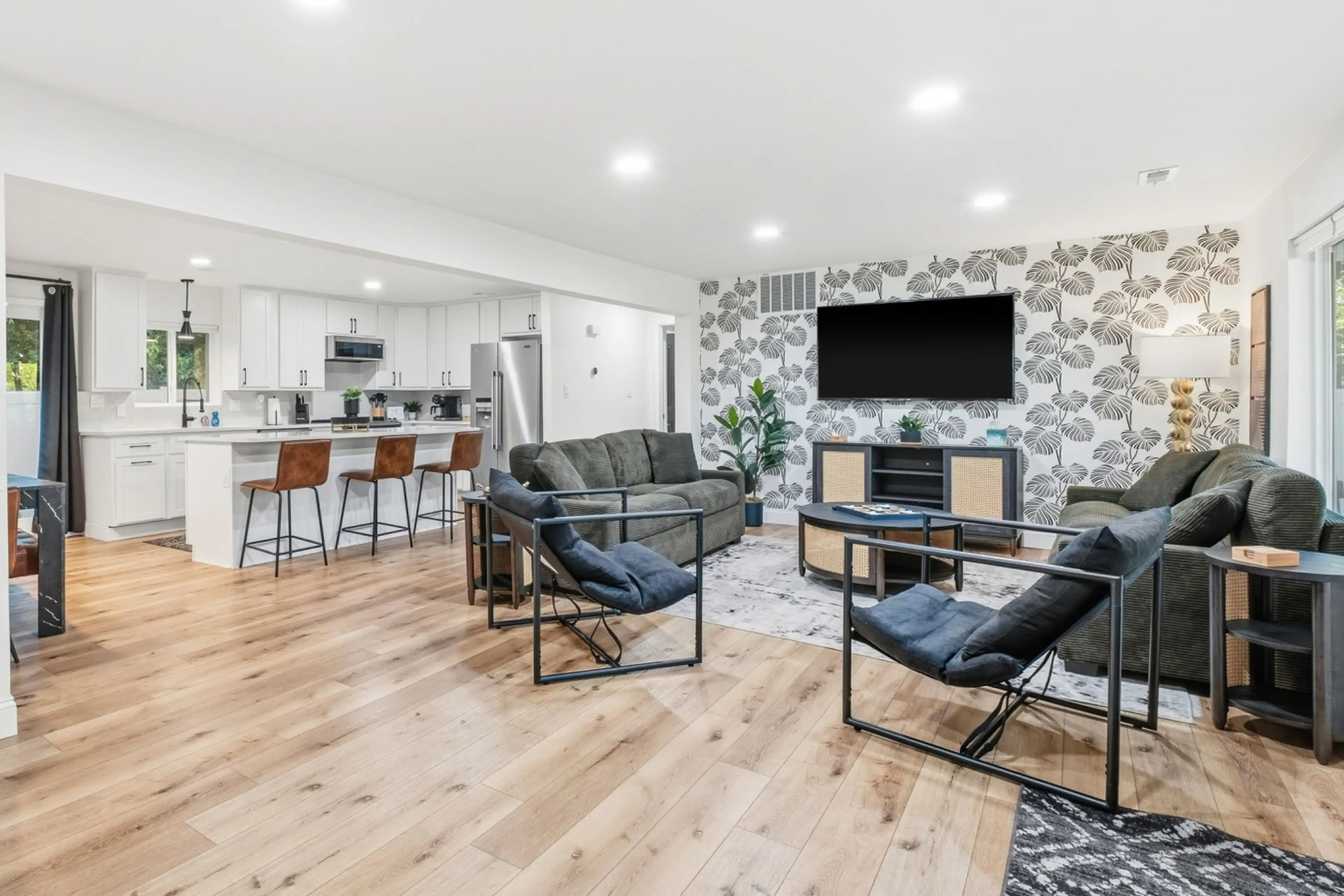 Discover a beautifully remodeled, open-concept living room that seamlessly flows into the kitchen, featuring new appliances, quartz countertops, and backsplash. Ideal for relaxing, entertaining, and family gatherings, it combines modern style