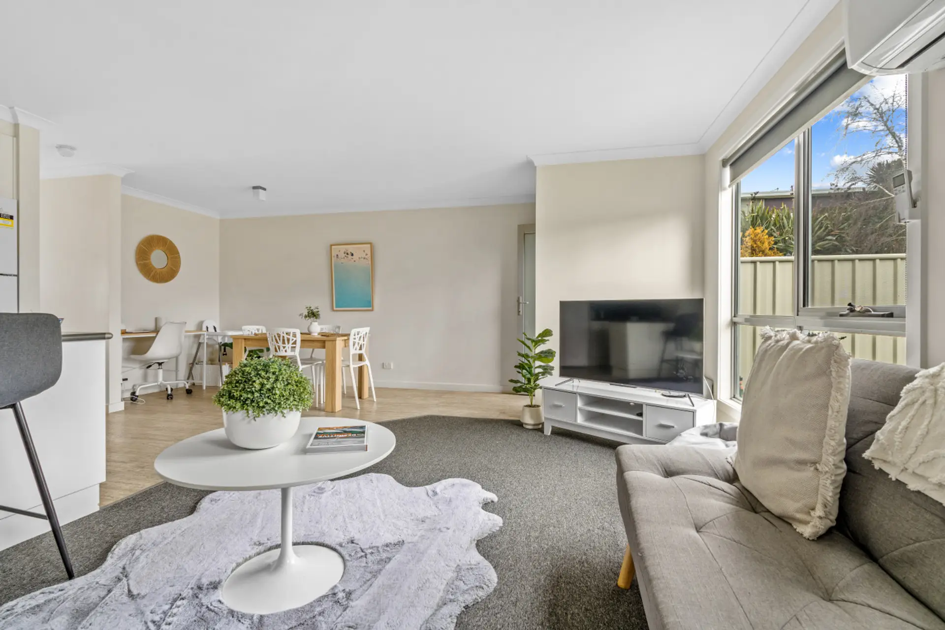 Lounge with smart TV, dining table and workspace beyond