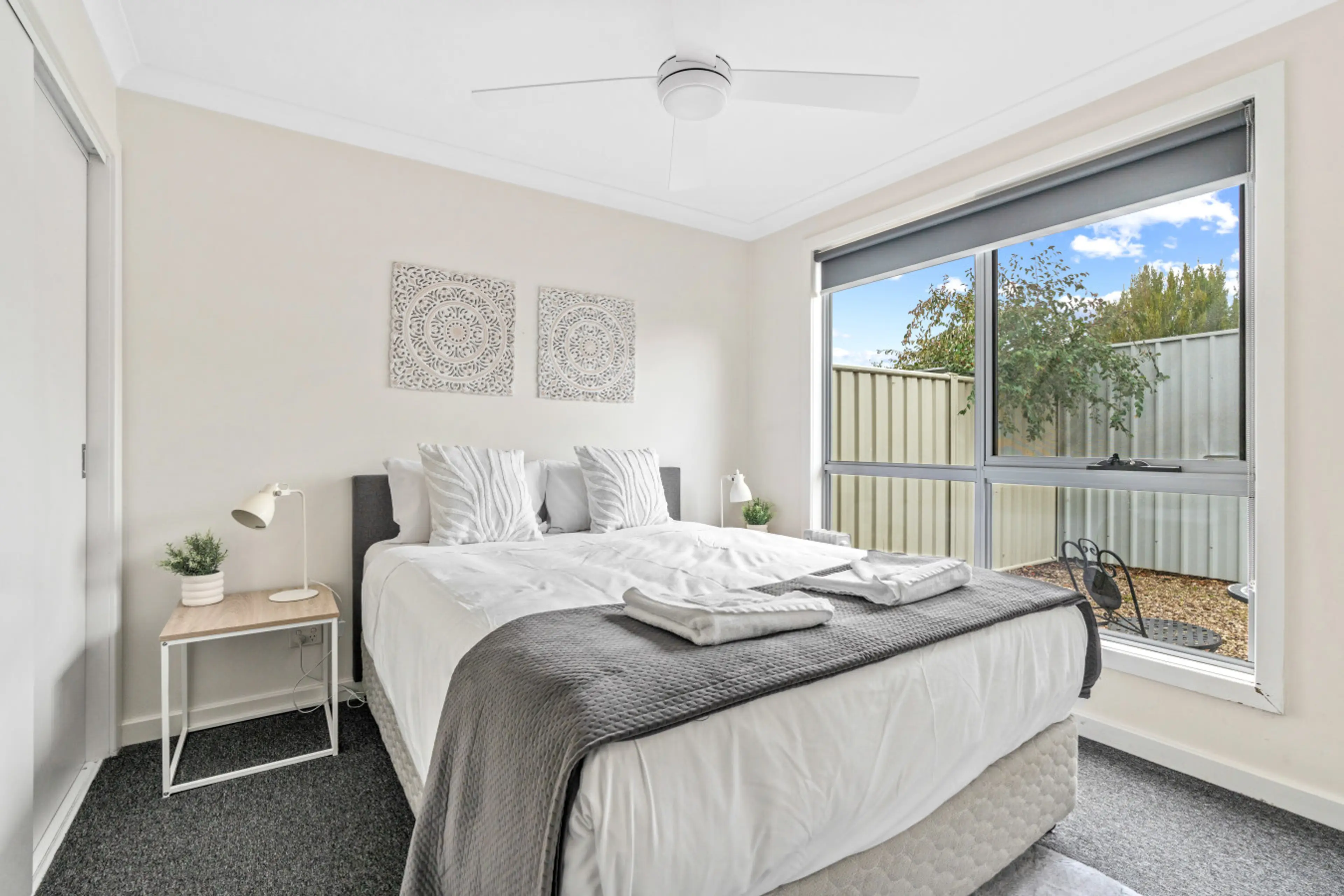 Master bedroom with queen bed, ceiling fan and garden view