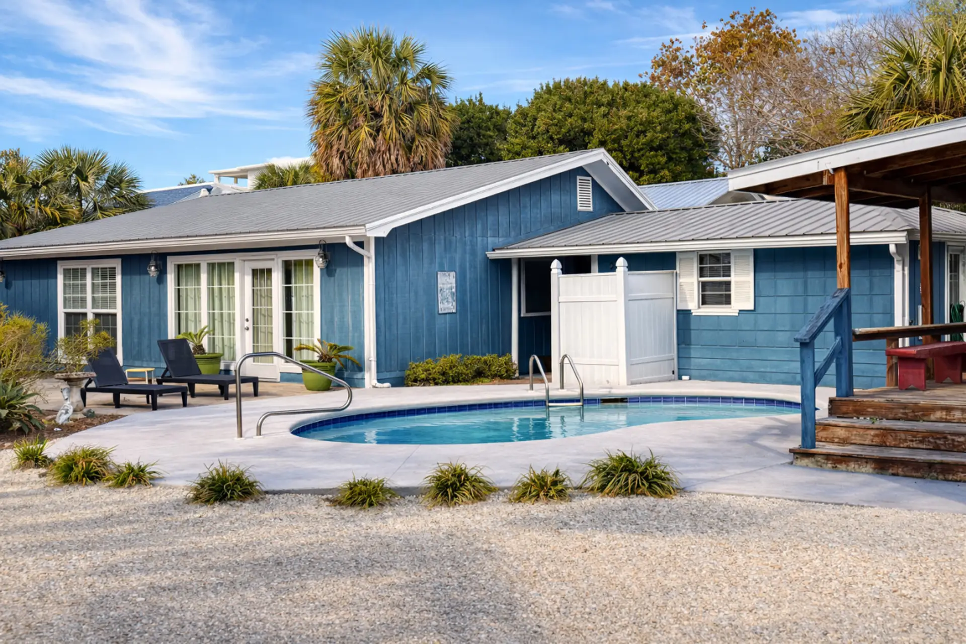 Private kidney pool with lounge chairs and palms