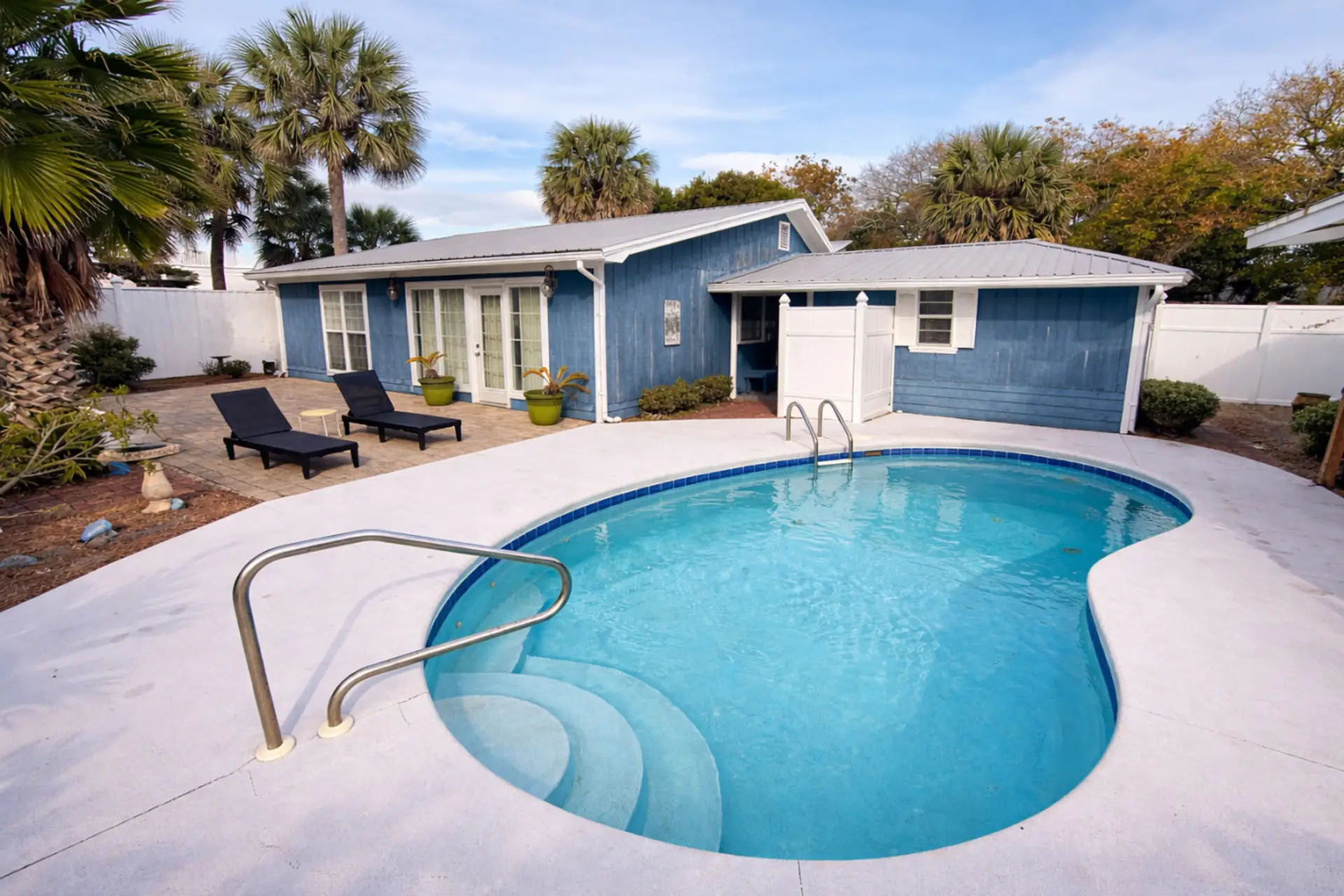 Sparkling backyard pool framed by palm trees