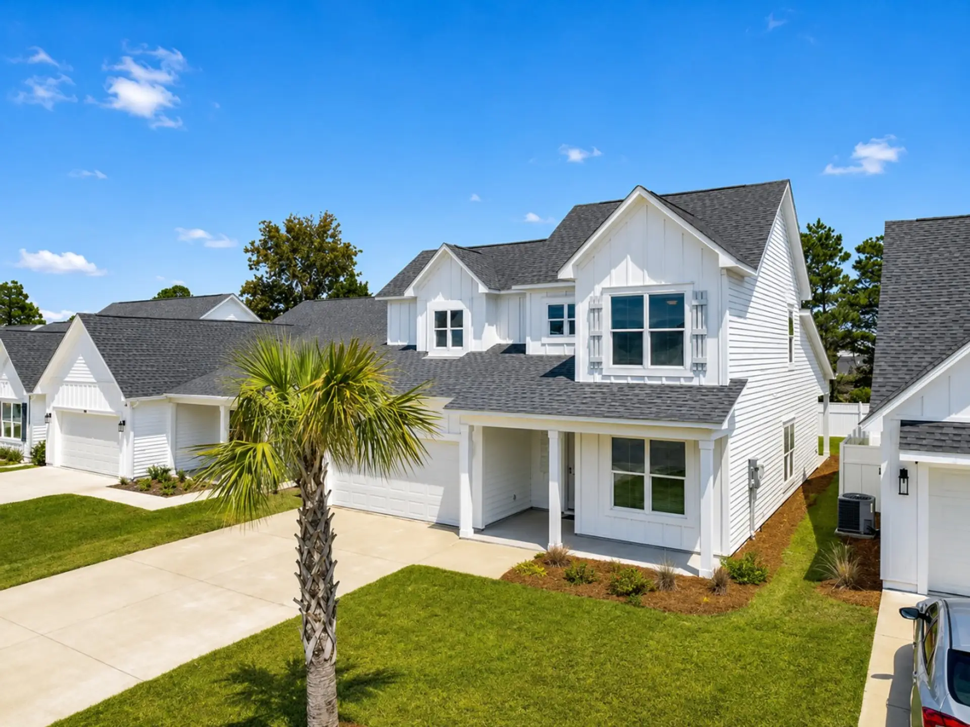 Exterior – Front street view of the home showing its bright coastal exterior, mature palm, and manicured landscaping.