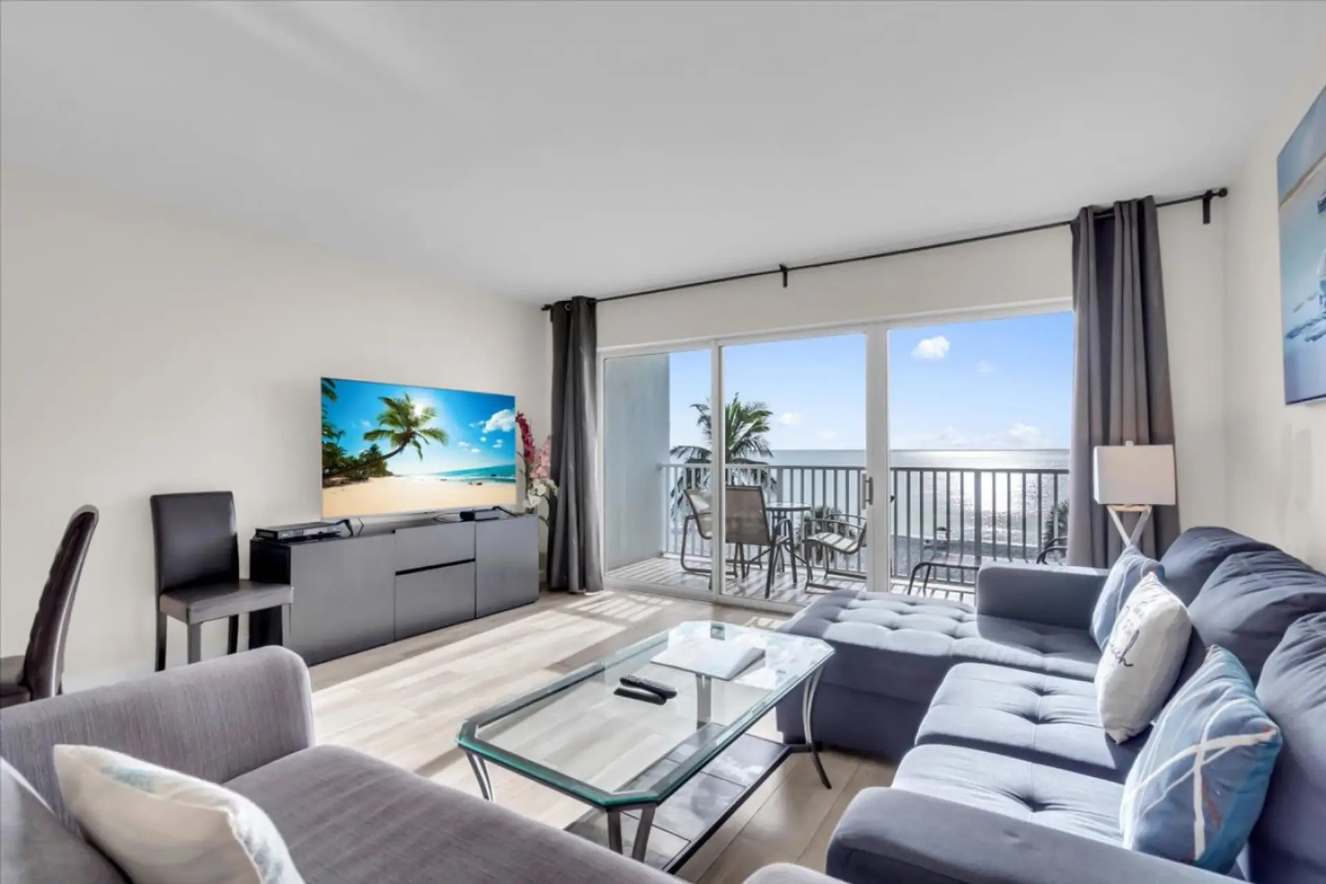 Spacious living room featuring modern furnishings, soft textures, and a serene coastal atmosphere.