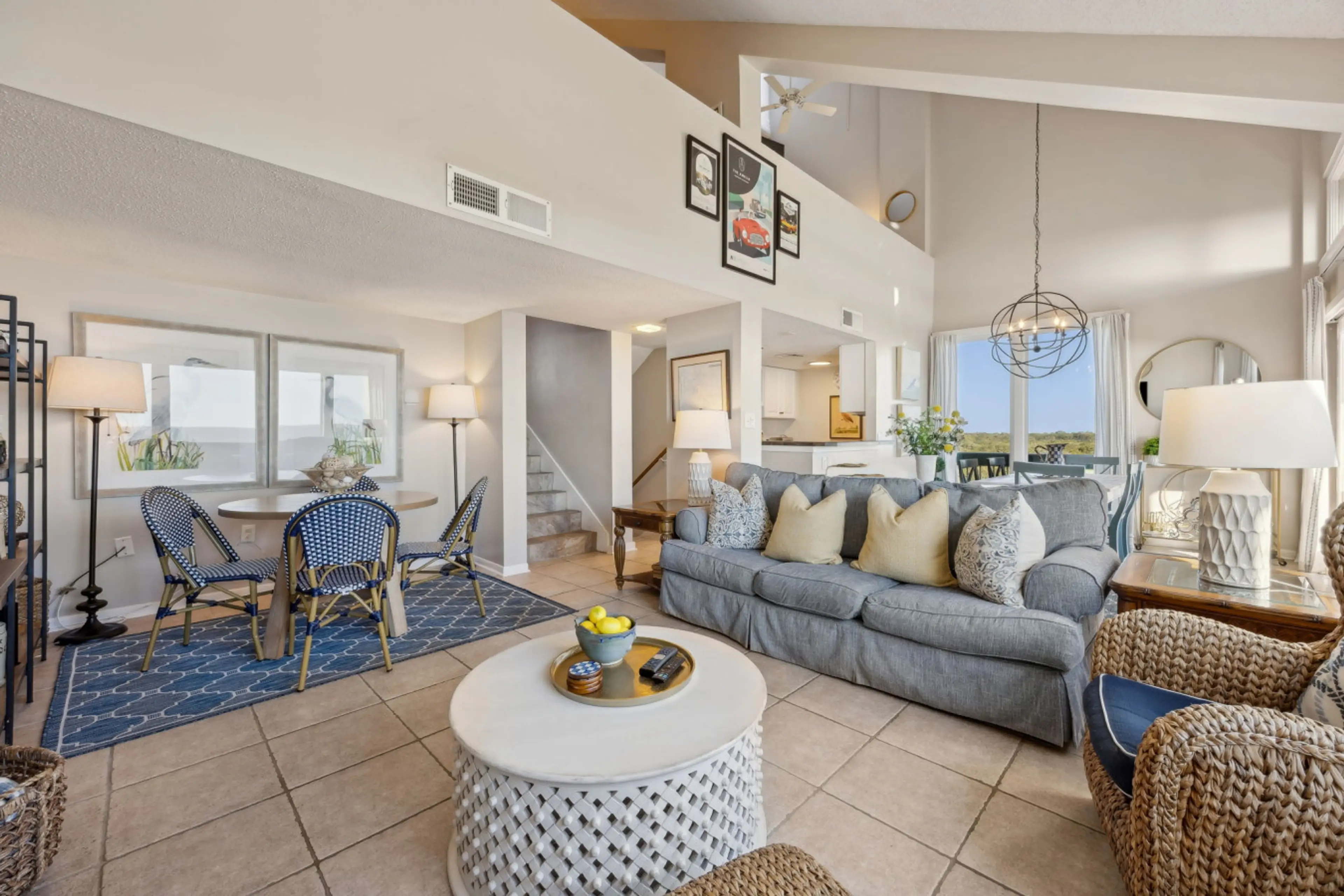 Airy coastal living space with vaulted ceilings, ocean views, and balcony access.