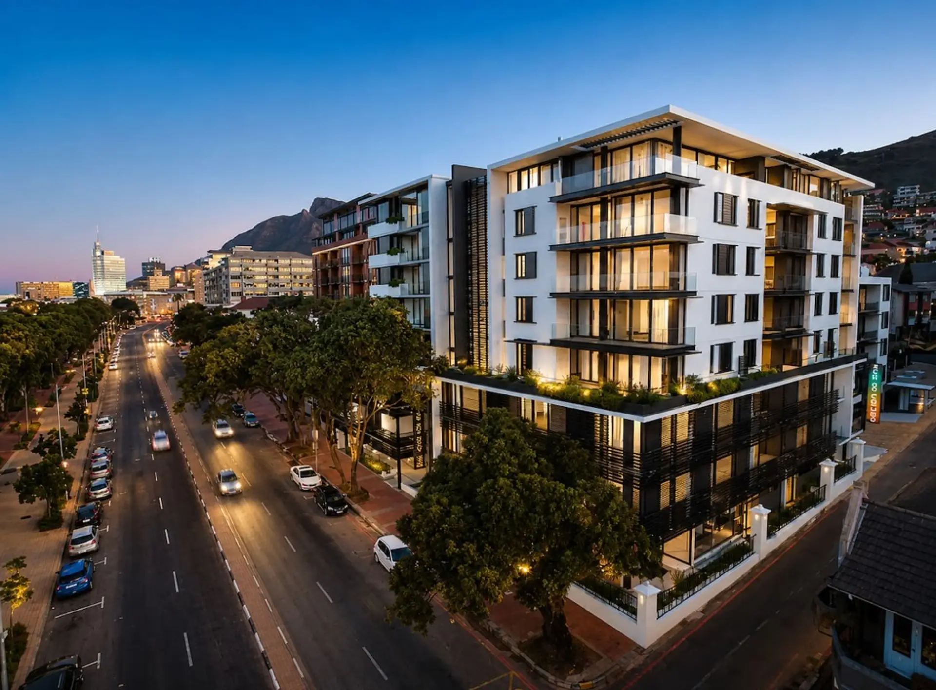 Exterior: Striking multi-story residence with glass-fronted balconies, landscaped terraces, and contemporary architecture, positioned along a tree-lined city street with mountain scenery beyond.
