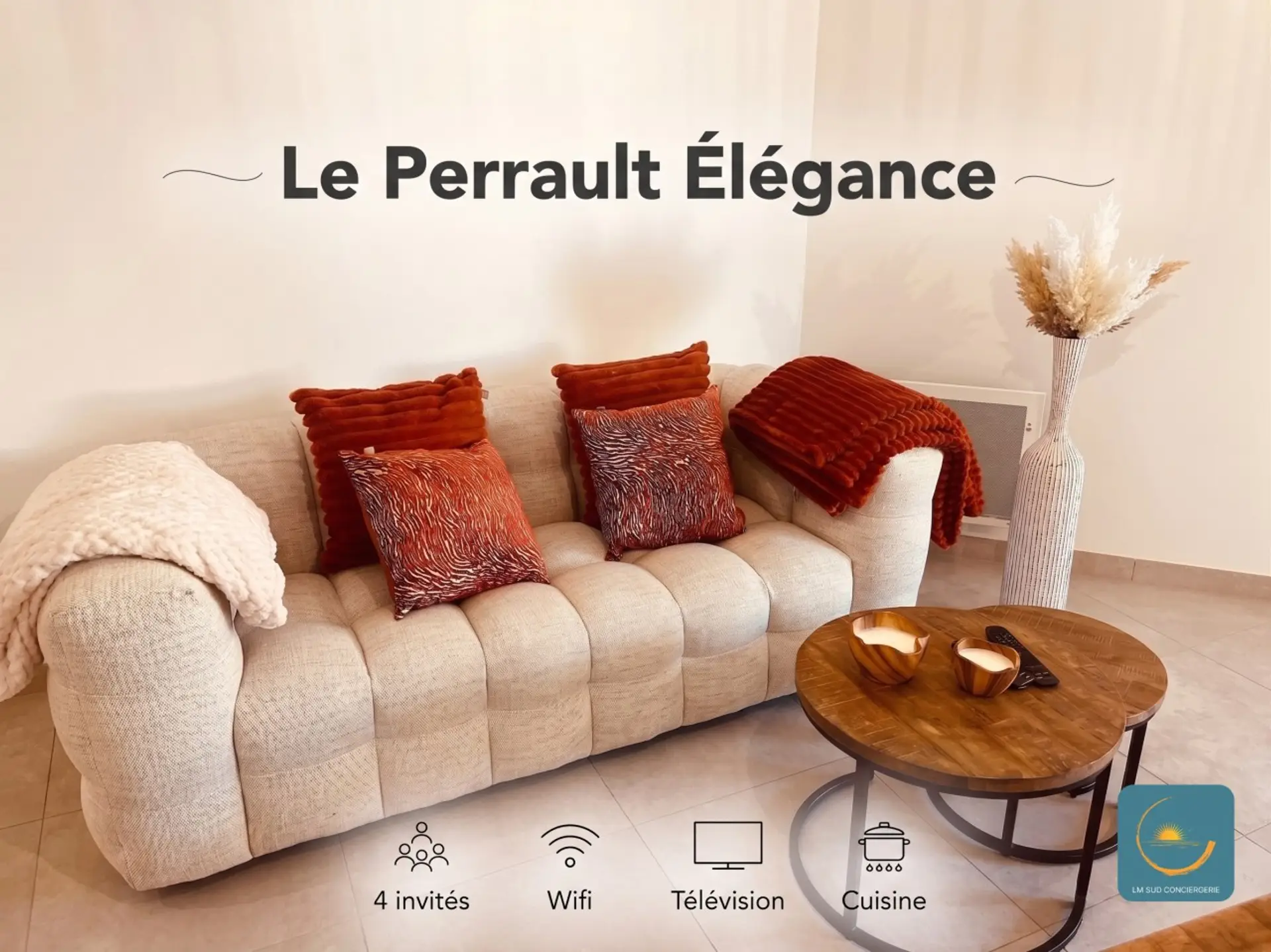 Salon chaleureux avec un canapé texturé beige agrémenté de coussins aux tons terracotta. Une table basse en bois apporte une touche moderne, tandis qu’un grand vase décoratif avec des pampas ajoute une note élégante.Lm sud Conciergerie Montpellier