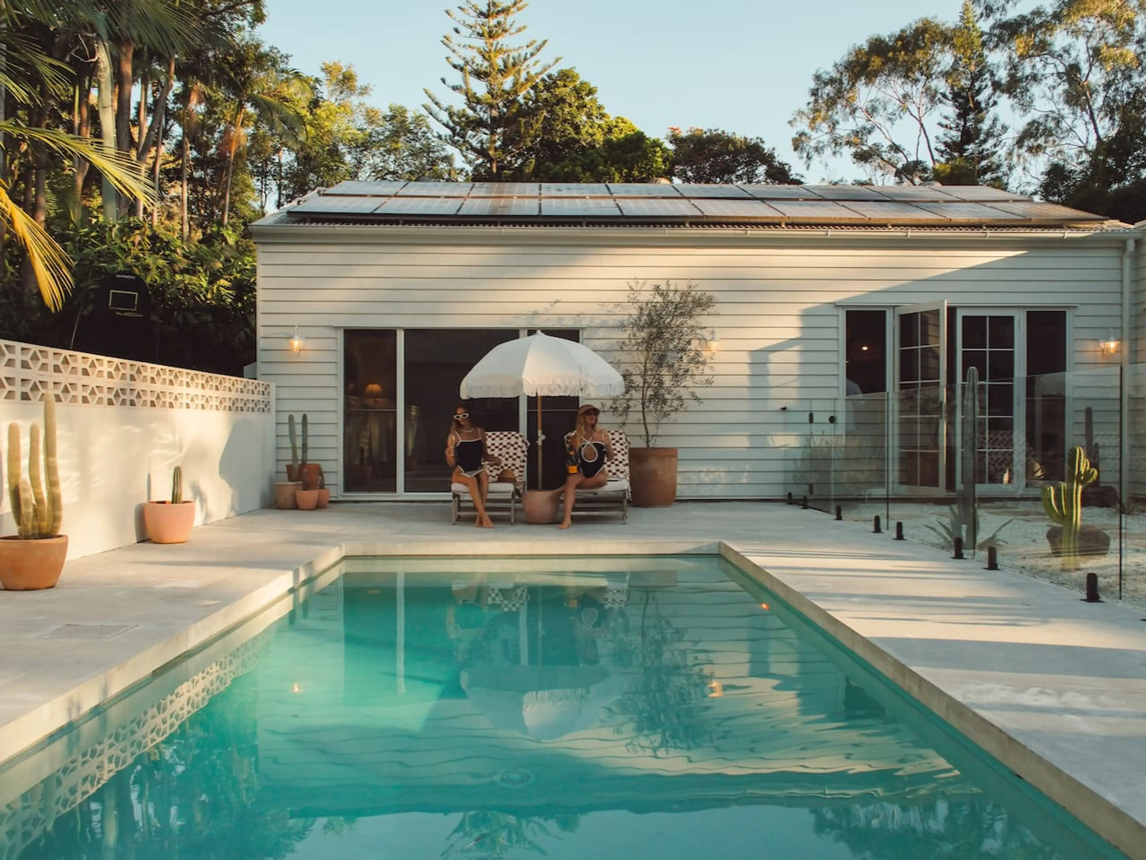 Outdoor pool area with loungers and sun umbrella.