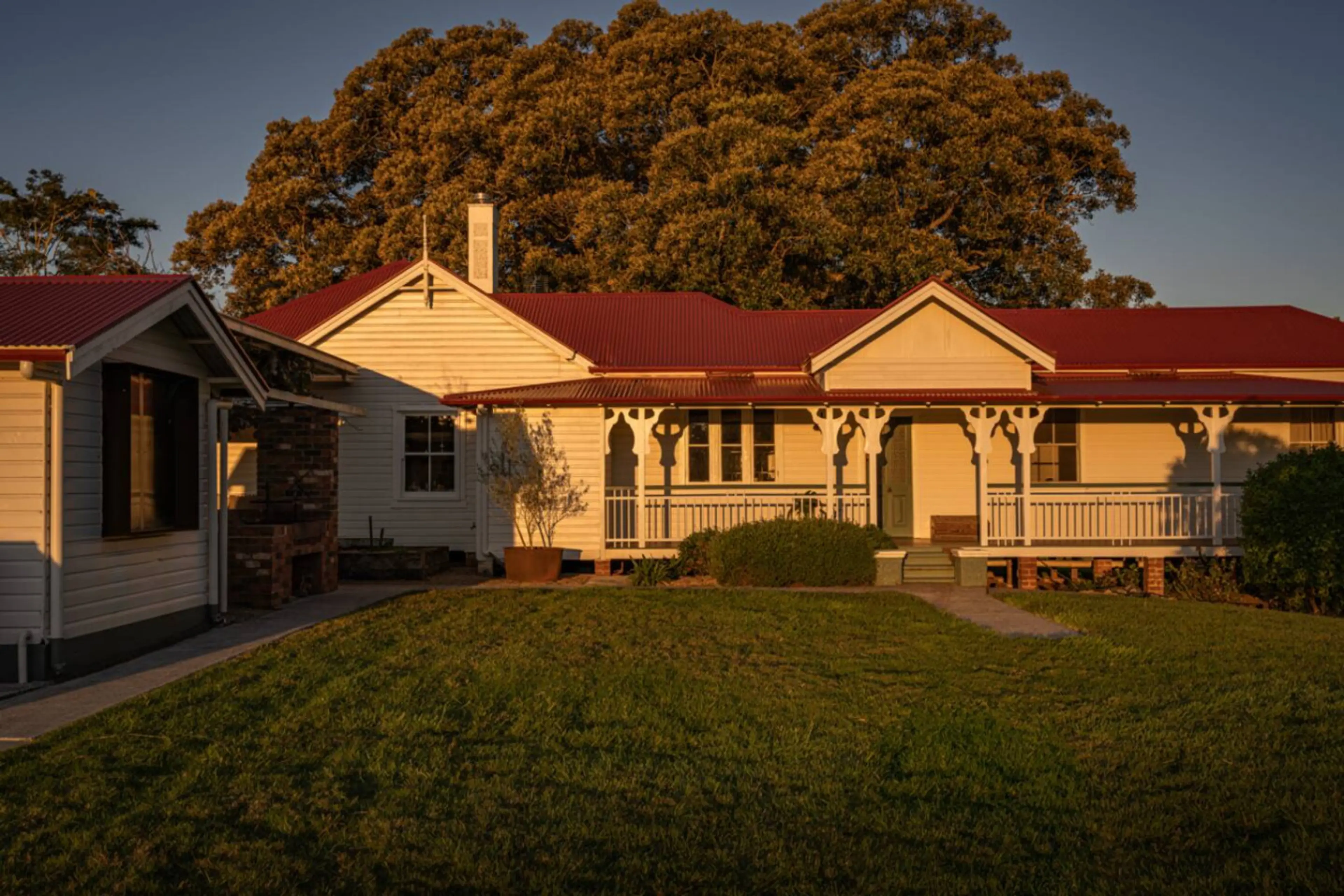 Heritage farmhouse with wraparound verandas and lawn views.