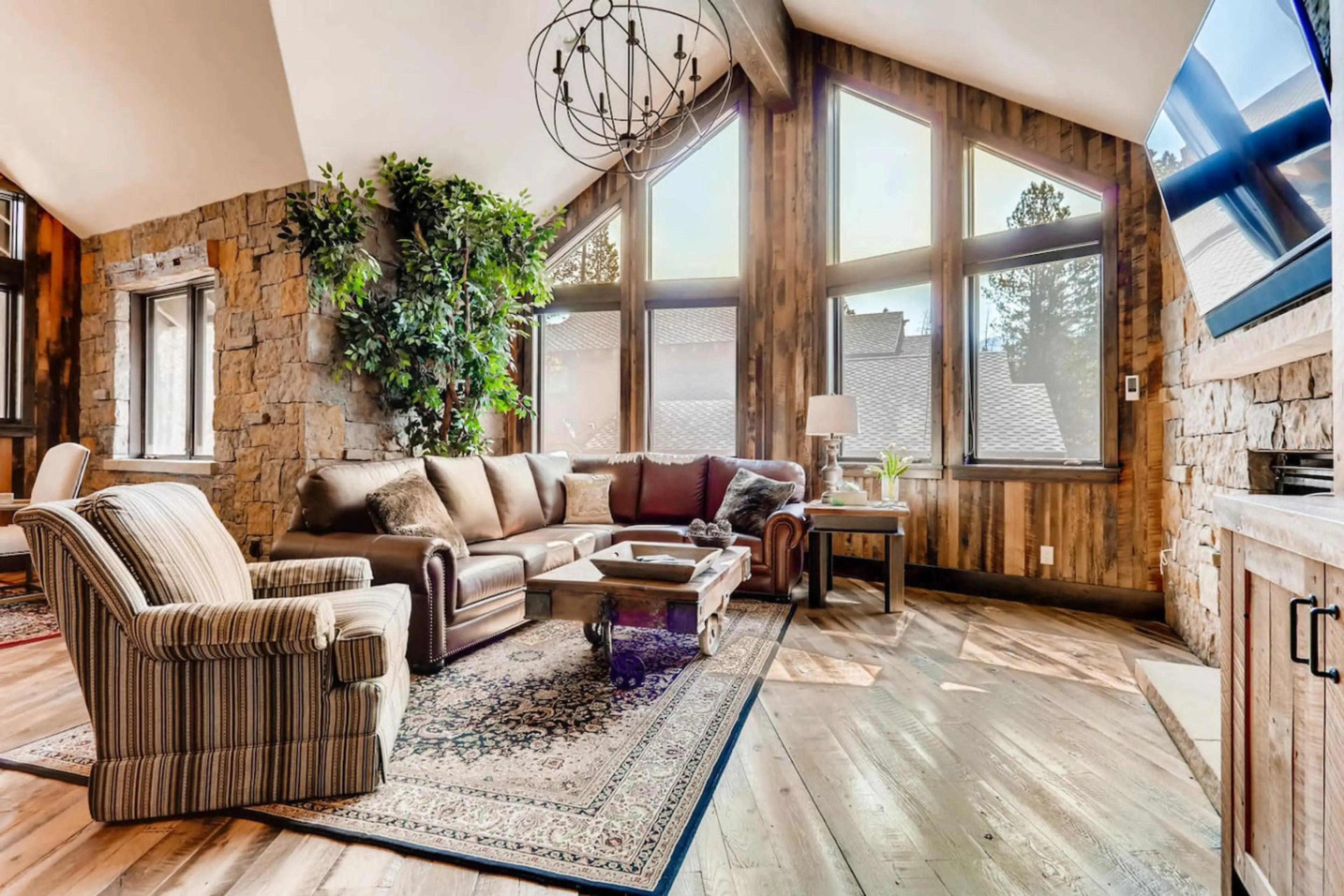 Luxurious and cozy great room with large windows, offering panoramic mountain views and a fireplace for ultimate comfort