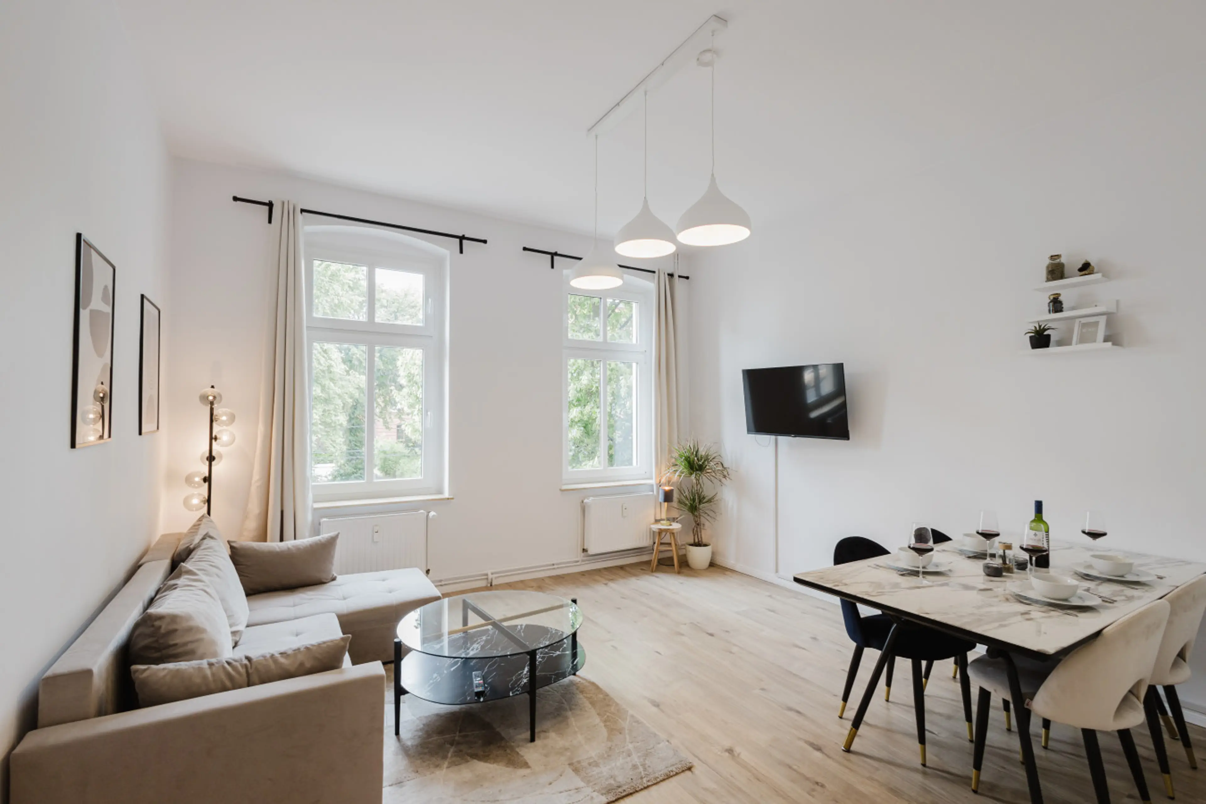Open-concept living and dining room with large windows and a cozy, modern touch.