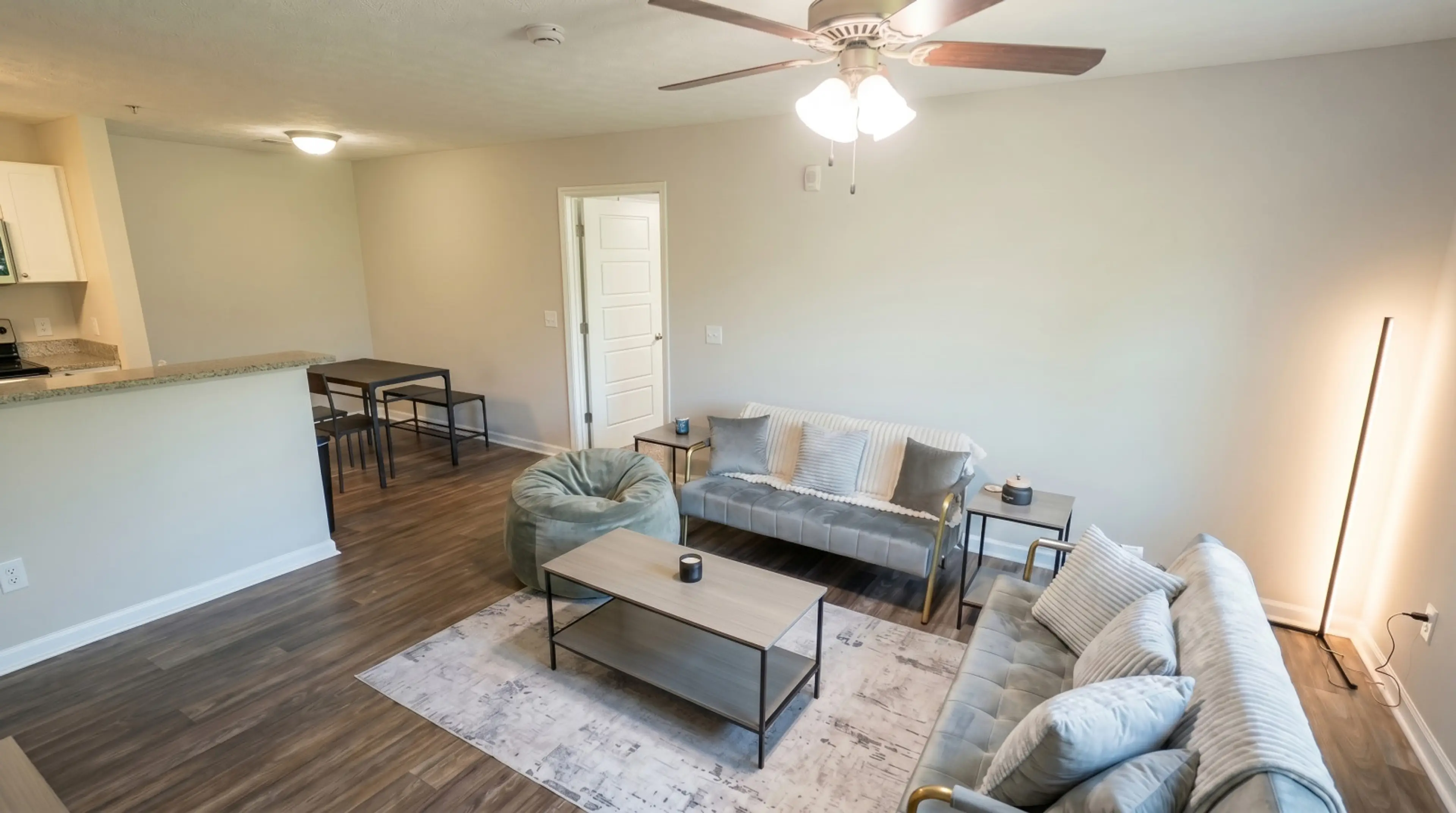 Spacious living room with natural light, ceiling fan, and comfortable seating. Furnished short-term rental in Columbus, GA — perfect for military TDY, PCS relocation, and extended stays near Fort Benning / Fort Moore.