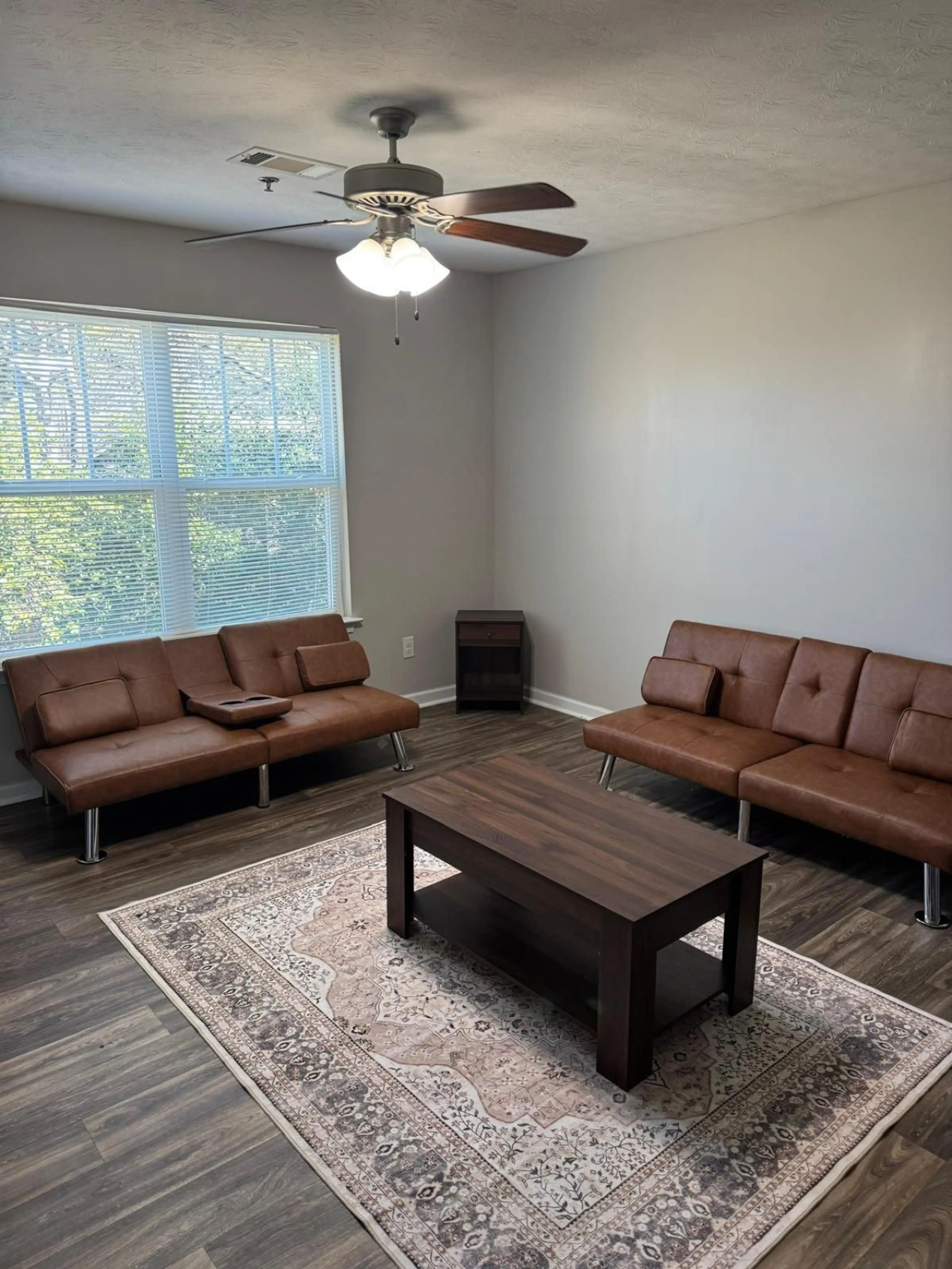 Spacious living room with natural light, ceiling fan, and comfortable seating. Furnished short-term rental in Columbus, GA — perfect for military TDY, PCS relocation, and extended stays near Fort Benning / Fort Moore.