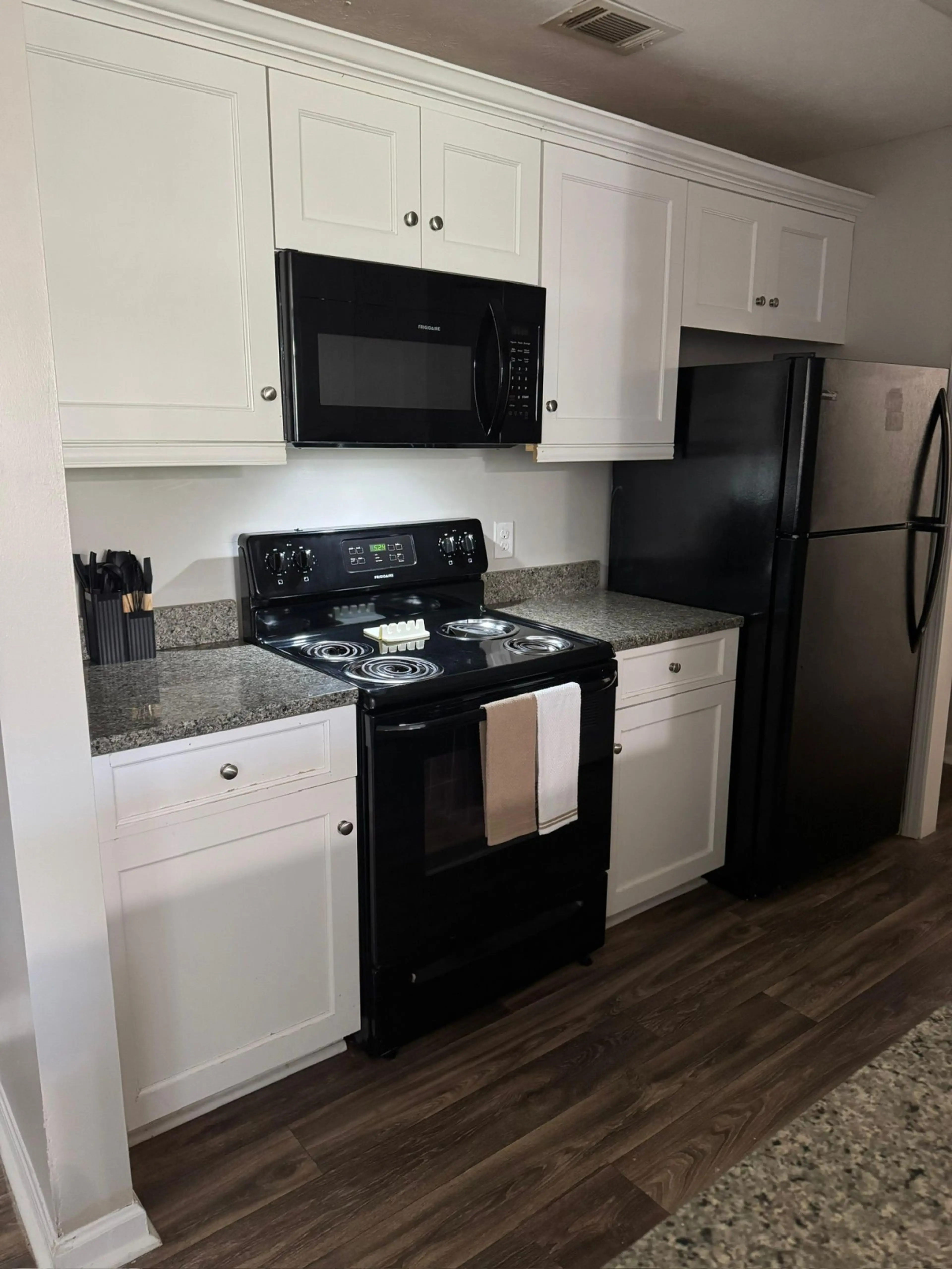 Fully equipped kitchen with full-size refrigerator, electric stove, microwave, and granite countertops. Furnished apartment for rent in Columbus, GA — ideal for extended stays, military relocation, and traveling professionals near Fort Benning.