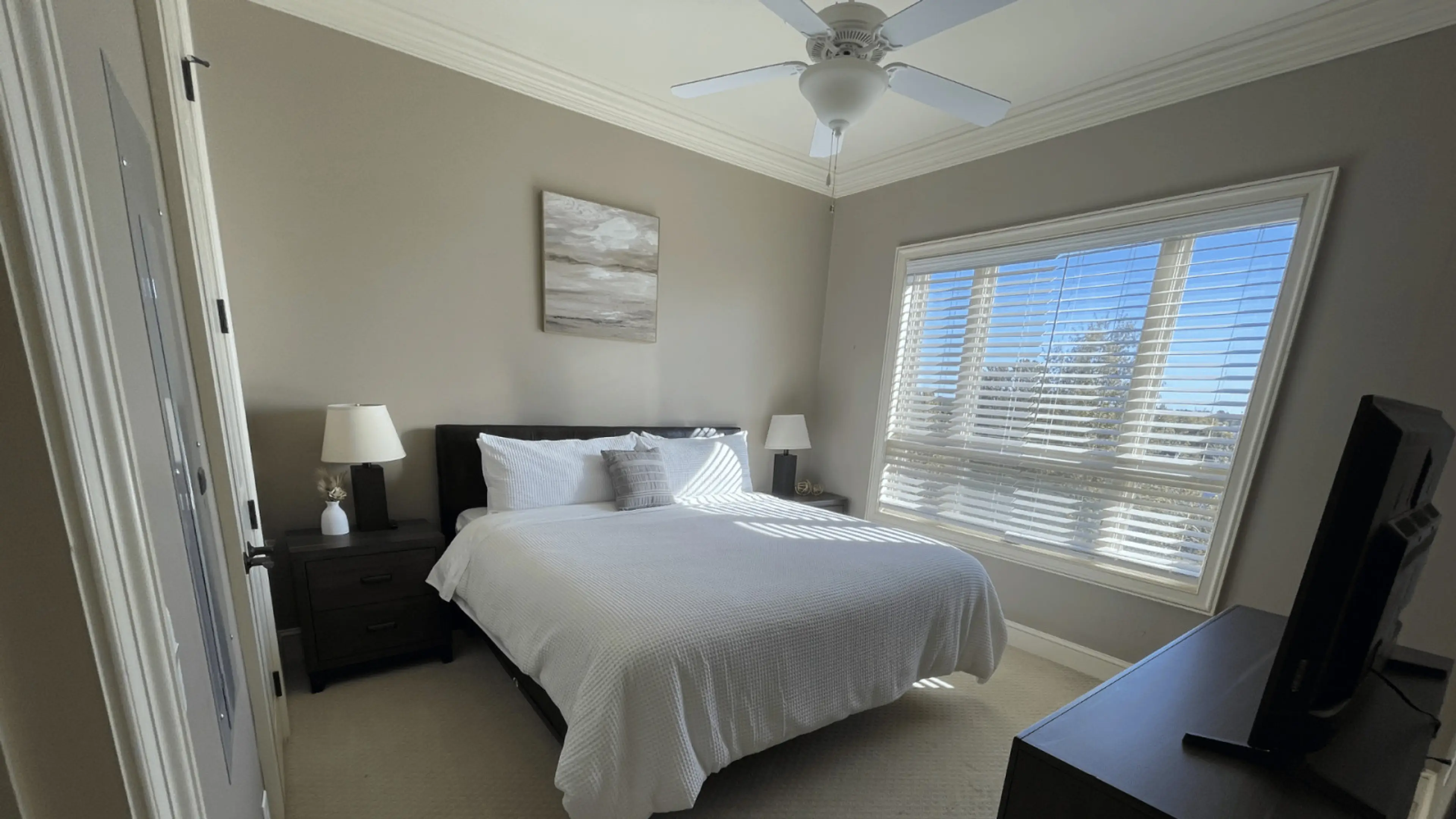 Comfortable and stylish bedroom with bright windows and soft linens — perfect for relaxing during your stay at The Gateway Village, Murfreesboro.
