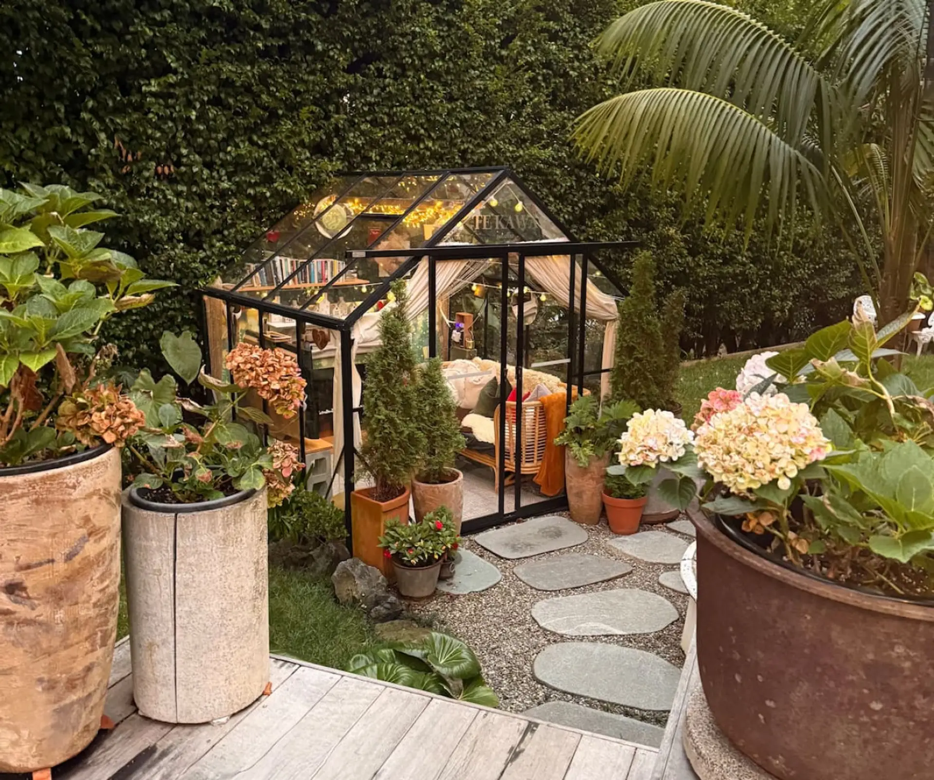 The glasshouse within the garden features an ever changing arrangement of plants and decorations
