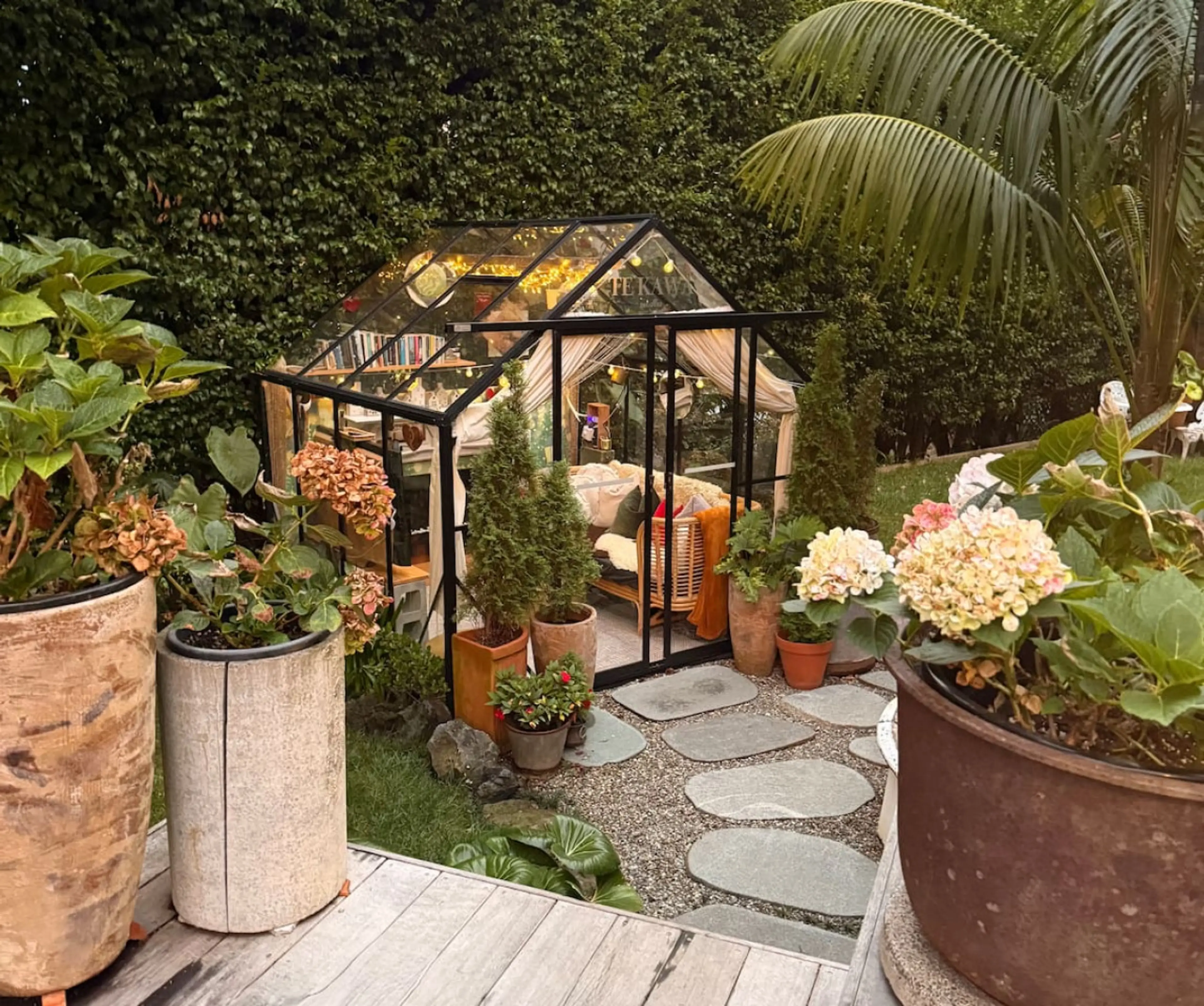 The glasshouse within the garden features an ever changing arrangement of plants and decorations