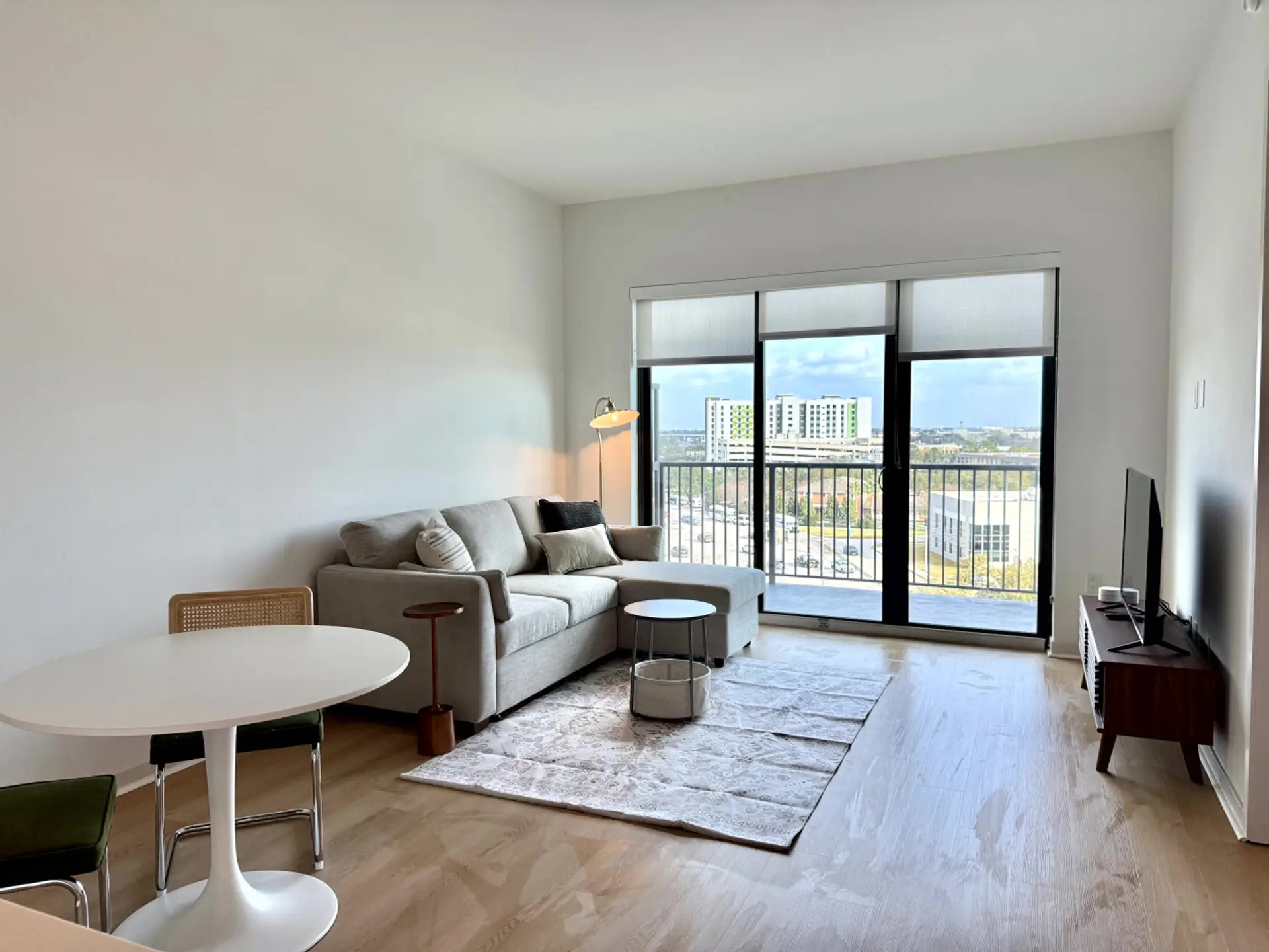 Floor-to-ceiling windows flood the open-concept living and dining space with natural light
