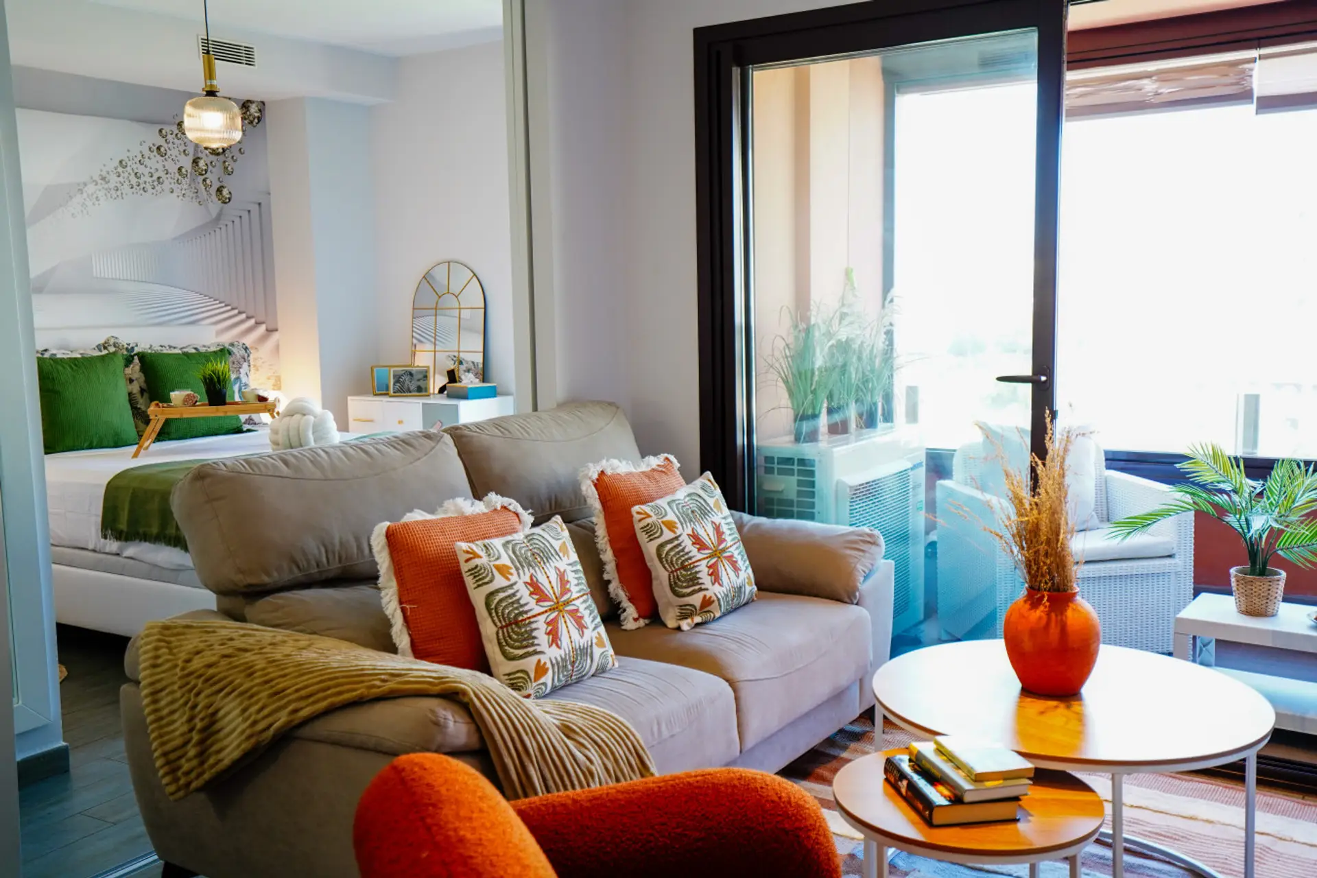 Zona de estar amplia y confortable con sofás en tonos neutros y detalles decorativos modernos. Las grandes ventanas permiten la entrada de abundante luz natural. Ideal para relajarse tras un día de paseo o trabajo.