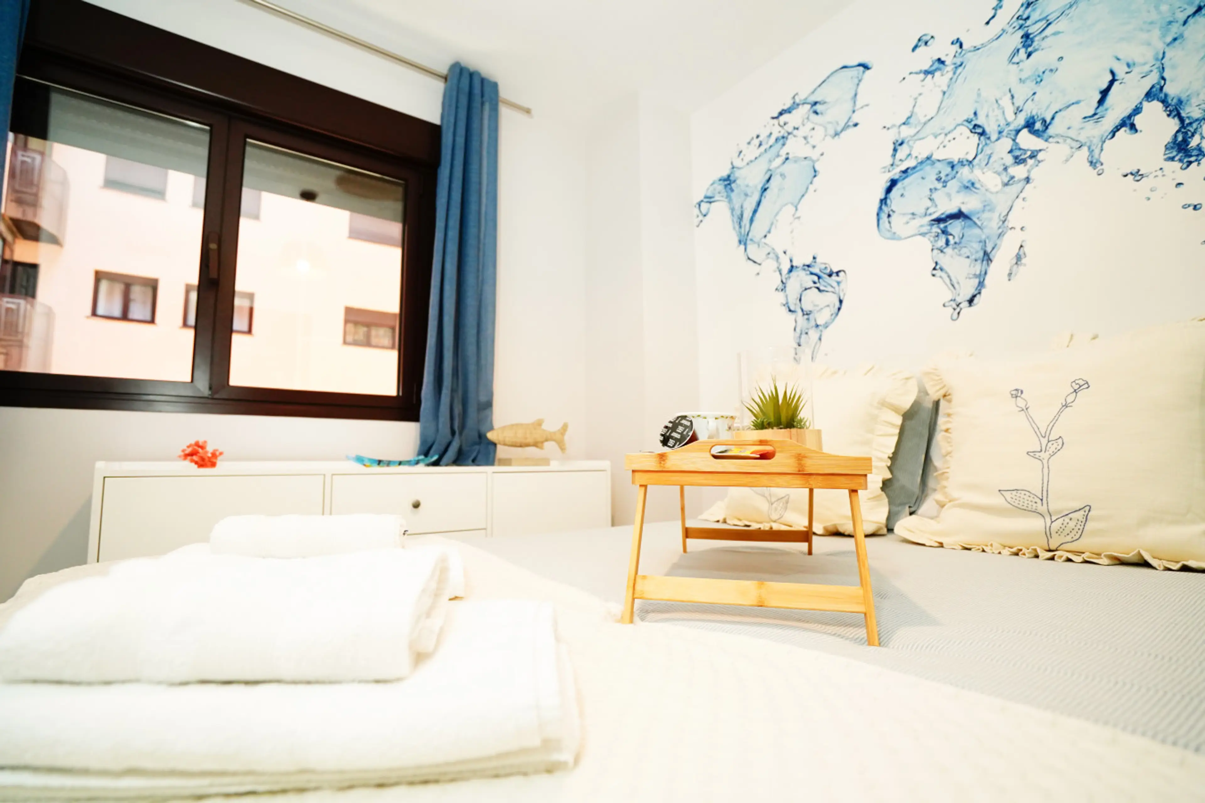 Plano general del dormitorio con cama perfectamente vestida y espacio despejado. Tonos neutros y elementos decorativos discretos crean una atmósfera serena. Espacio pensado para un sueño reparador y fácil organización.