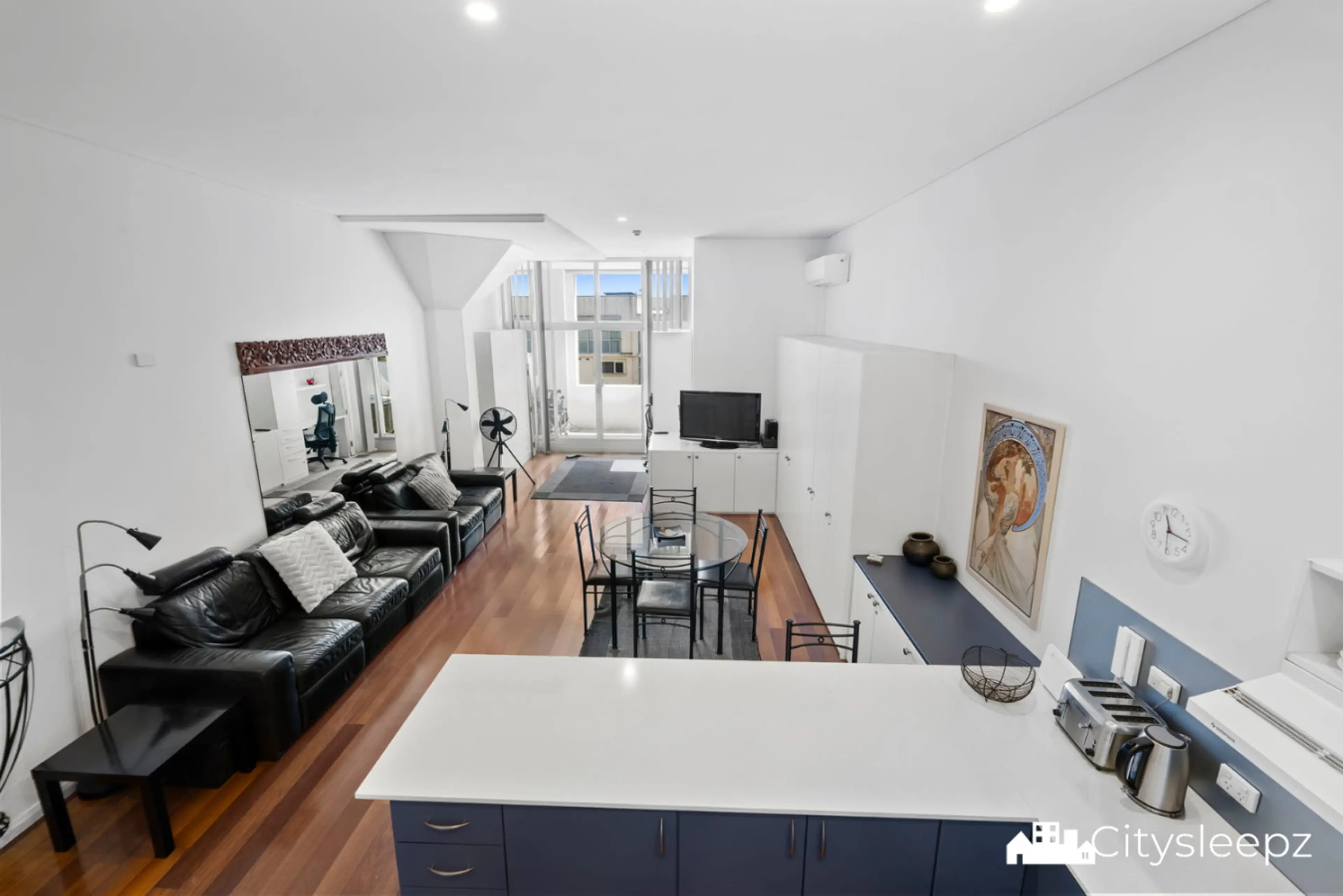 The view from the bedroom window looks into the open-plan living, kitchen, and dining area.