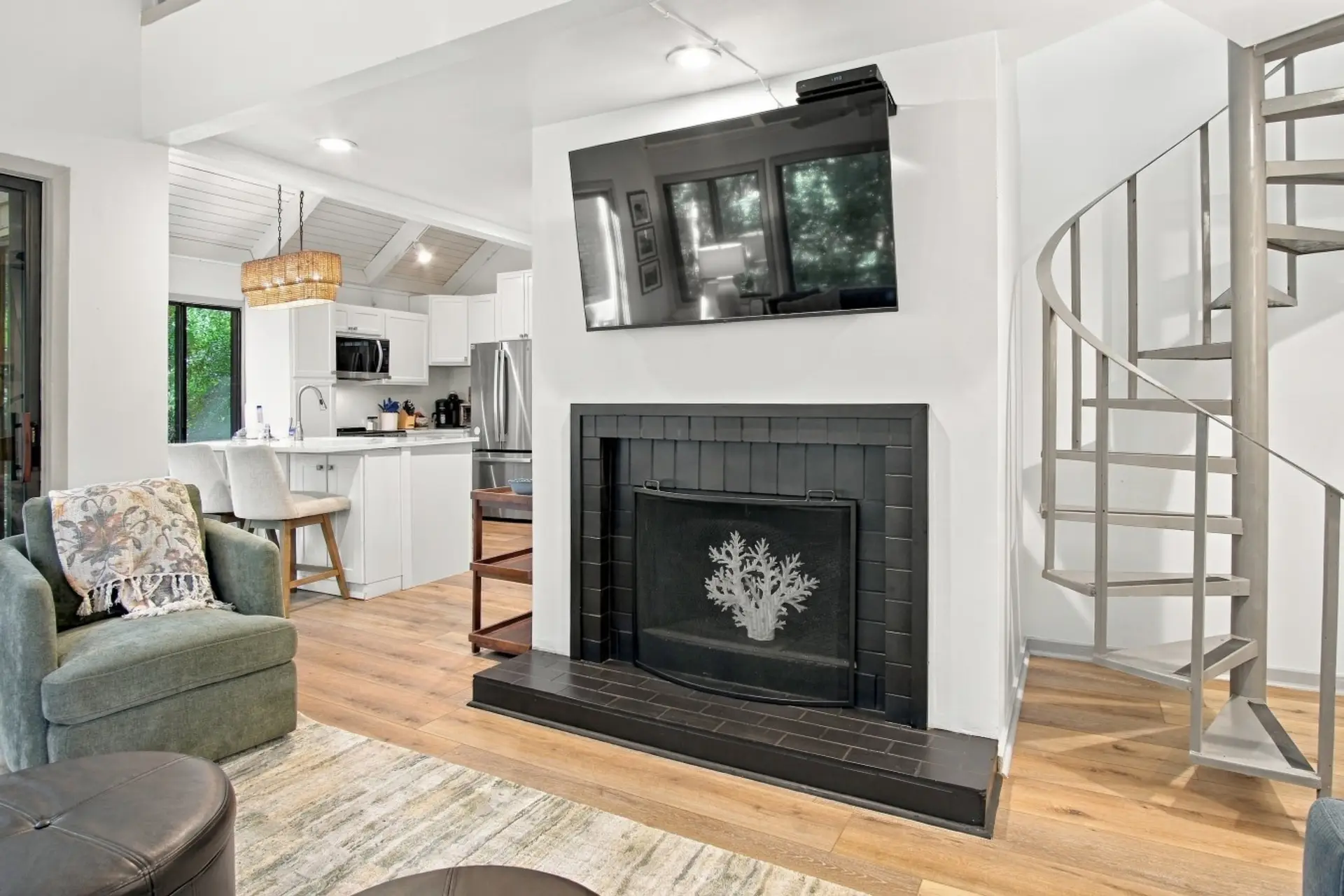 Decorative fireplace and Samsung Smart TV, spiral staircase to loft.