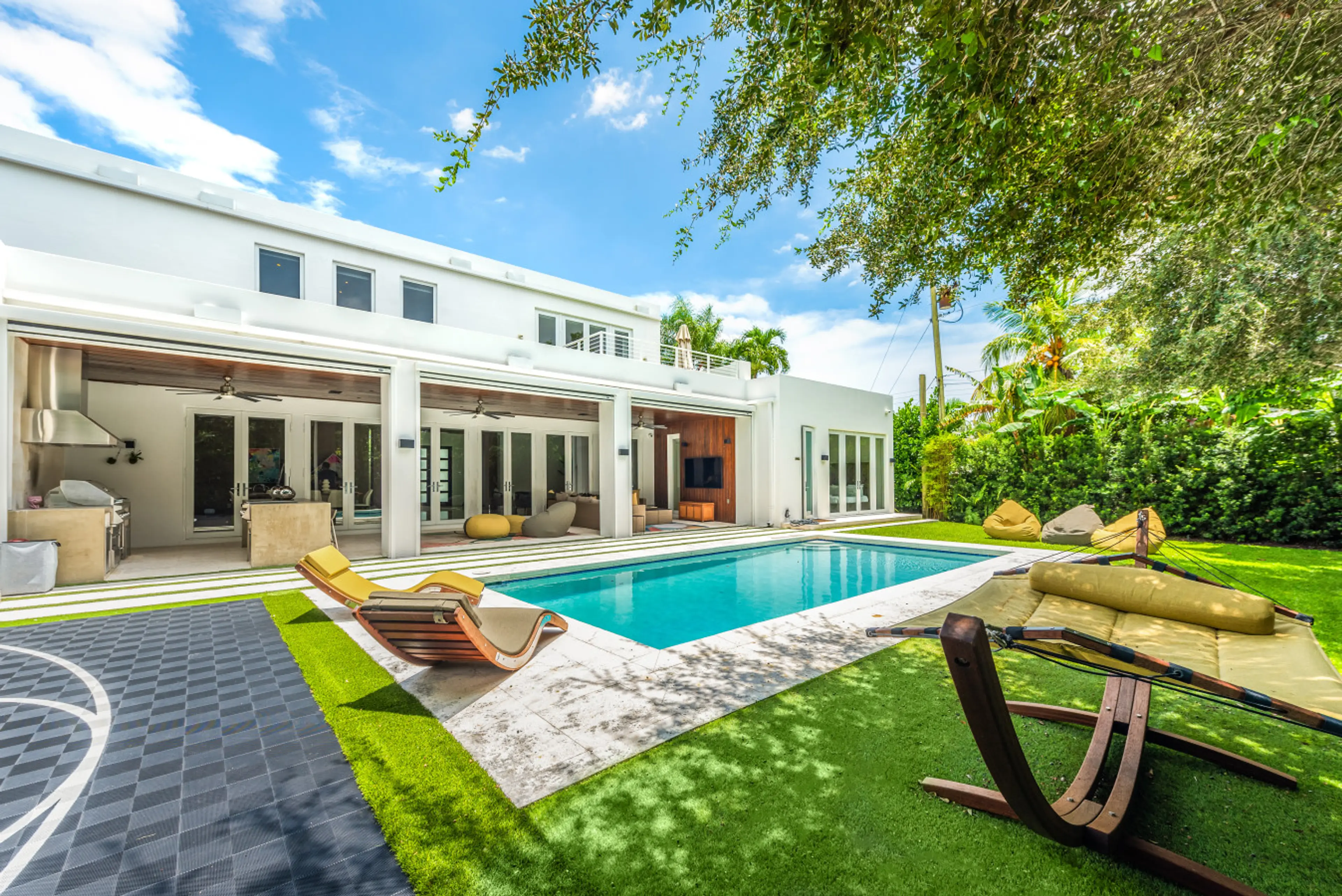 Spacious pool area with sun chairs and garden views