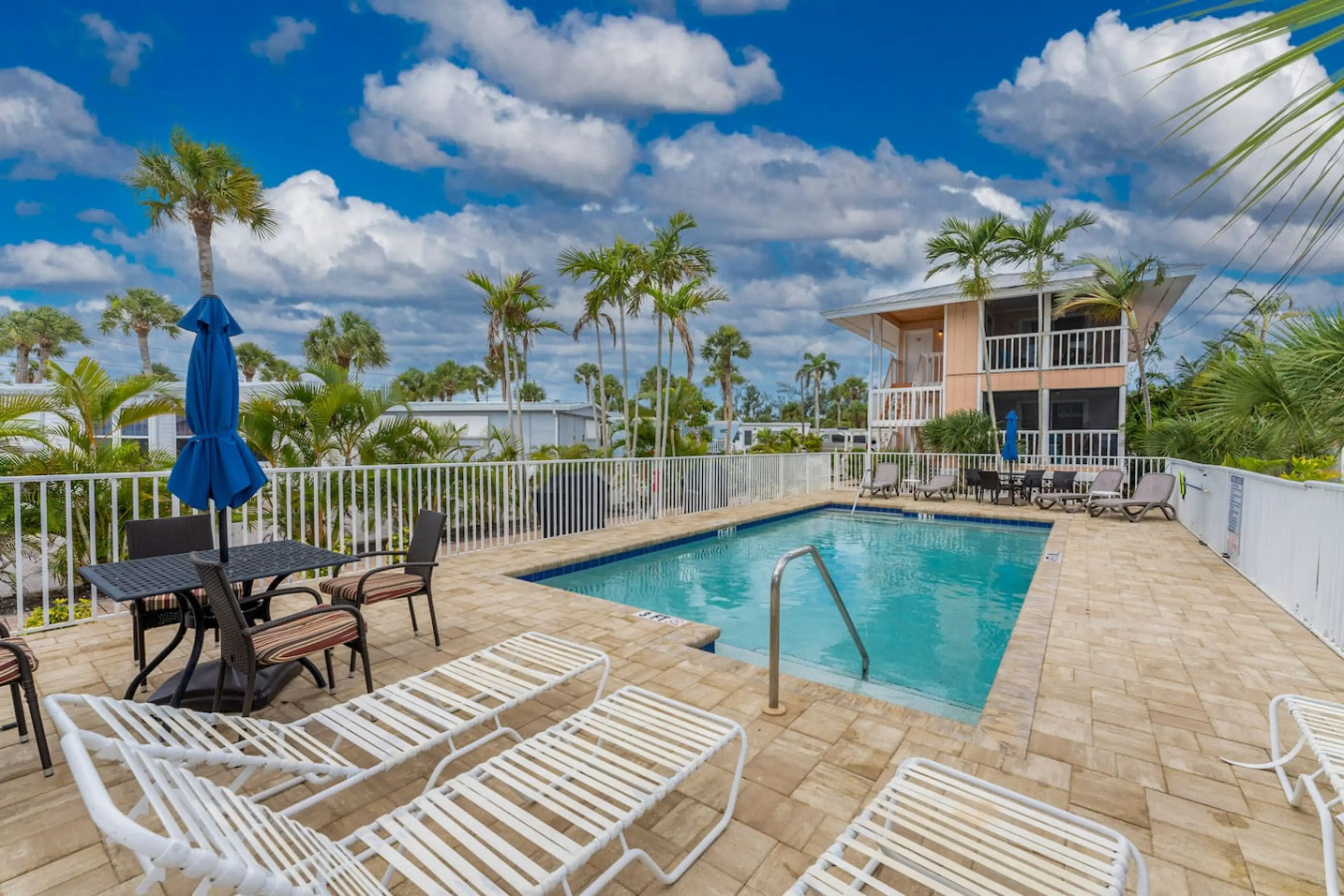 Shared Heated Pool has Sun Loungers and Dining Tables with Umbrellas