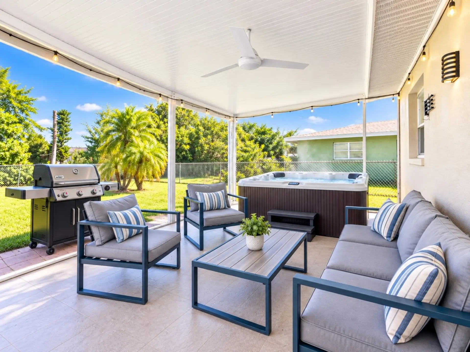 Screened lanai with private hot tub, outdoor lounge seating, and BBQ grill at Sunkissed on Annapolis in Rotonda West, Florida.