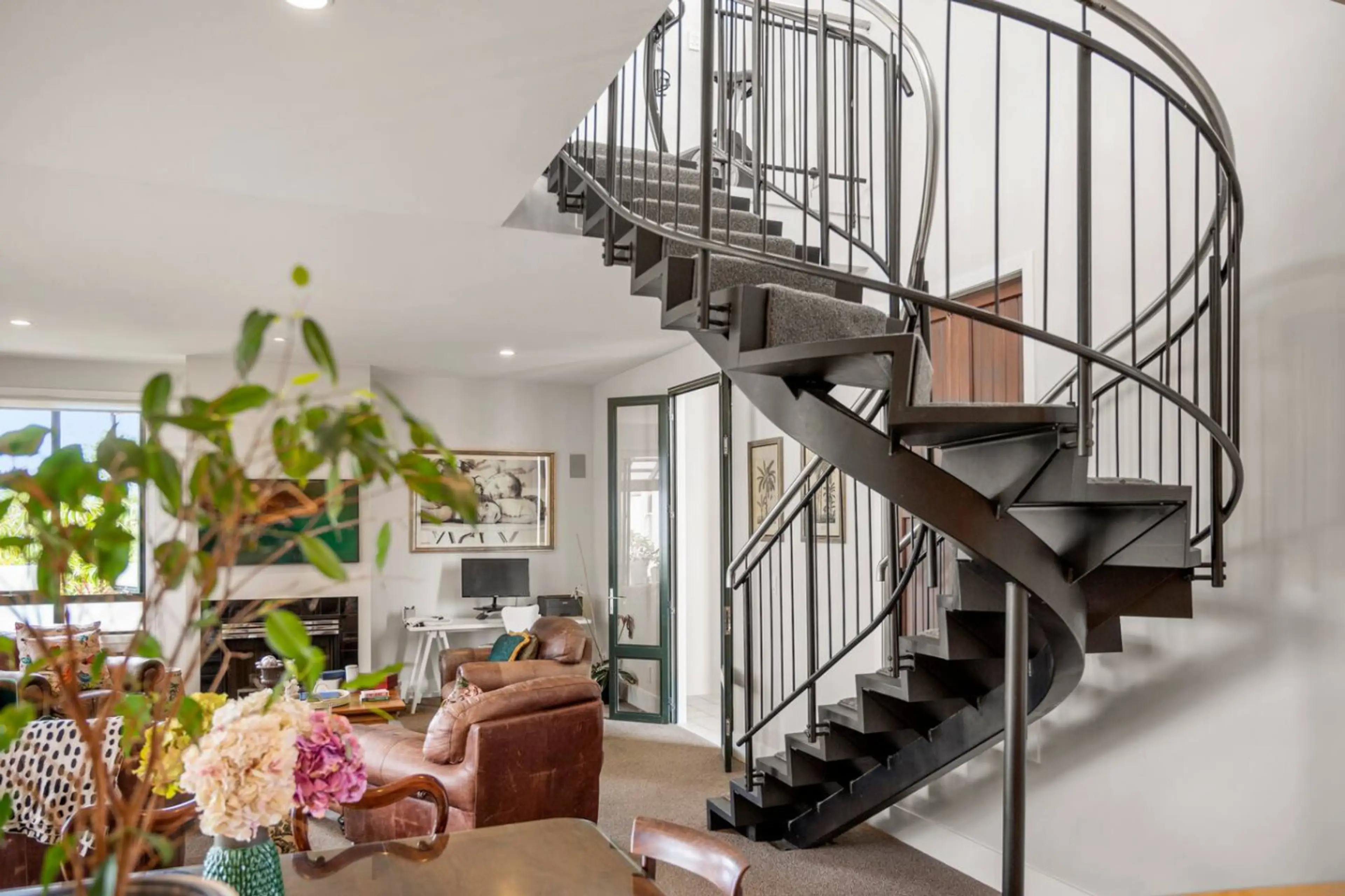 Open plan kitchen, dining and living, complete with cosy couches, and views over the harbour and sky tower