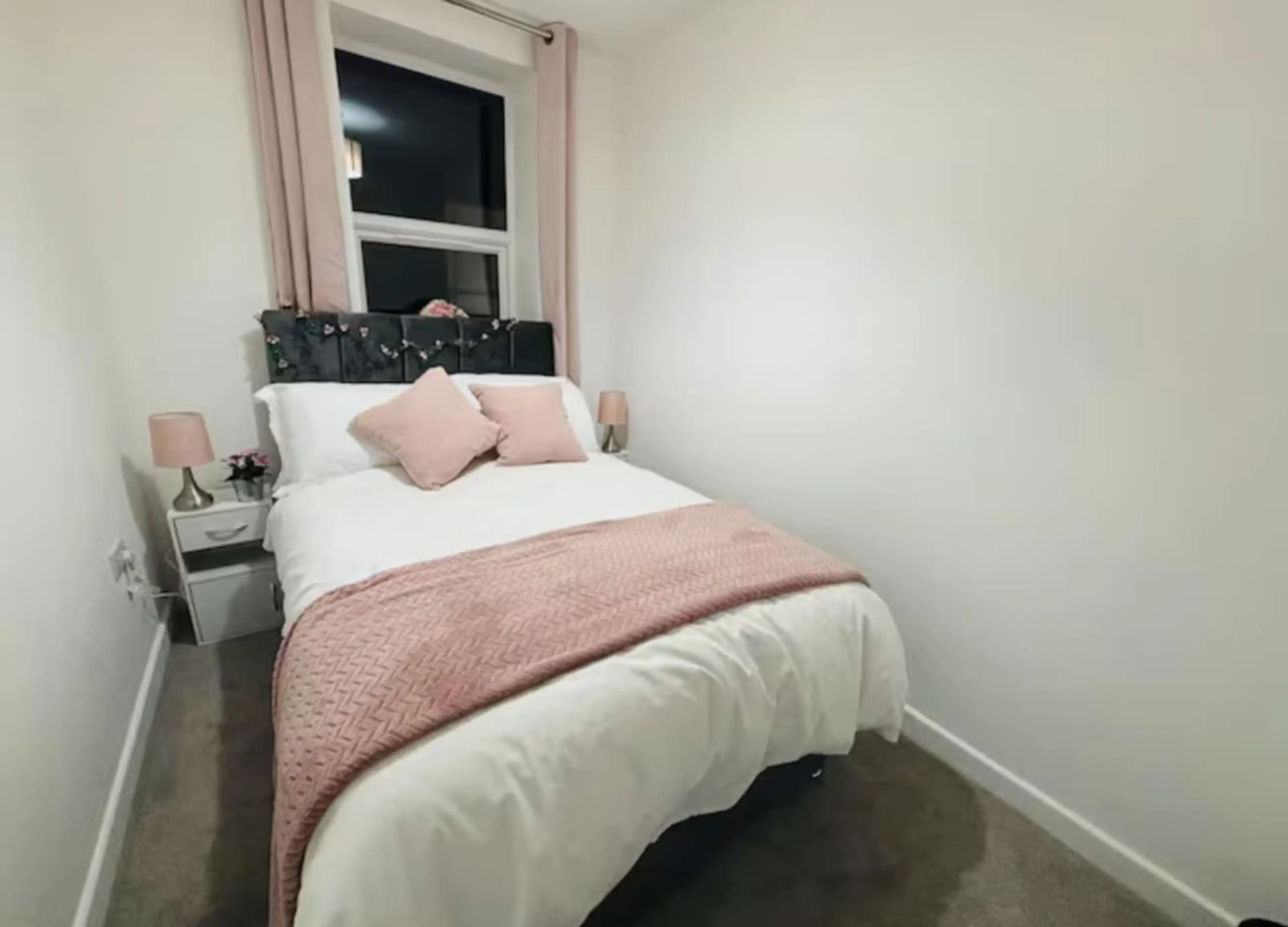 Cozy bed with fresh linens, blackout shades, and storage.