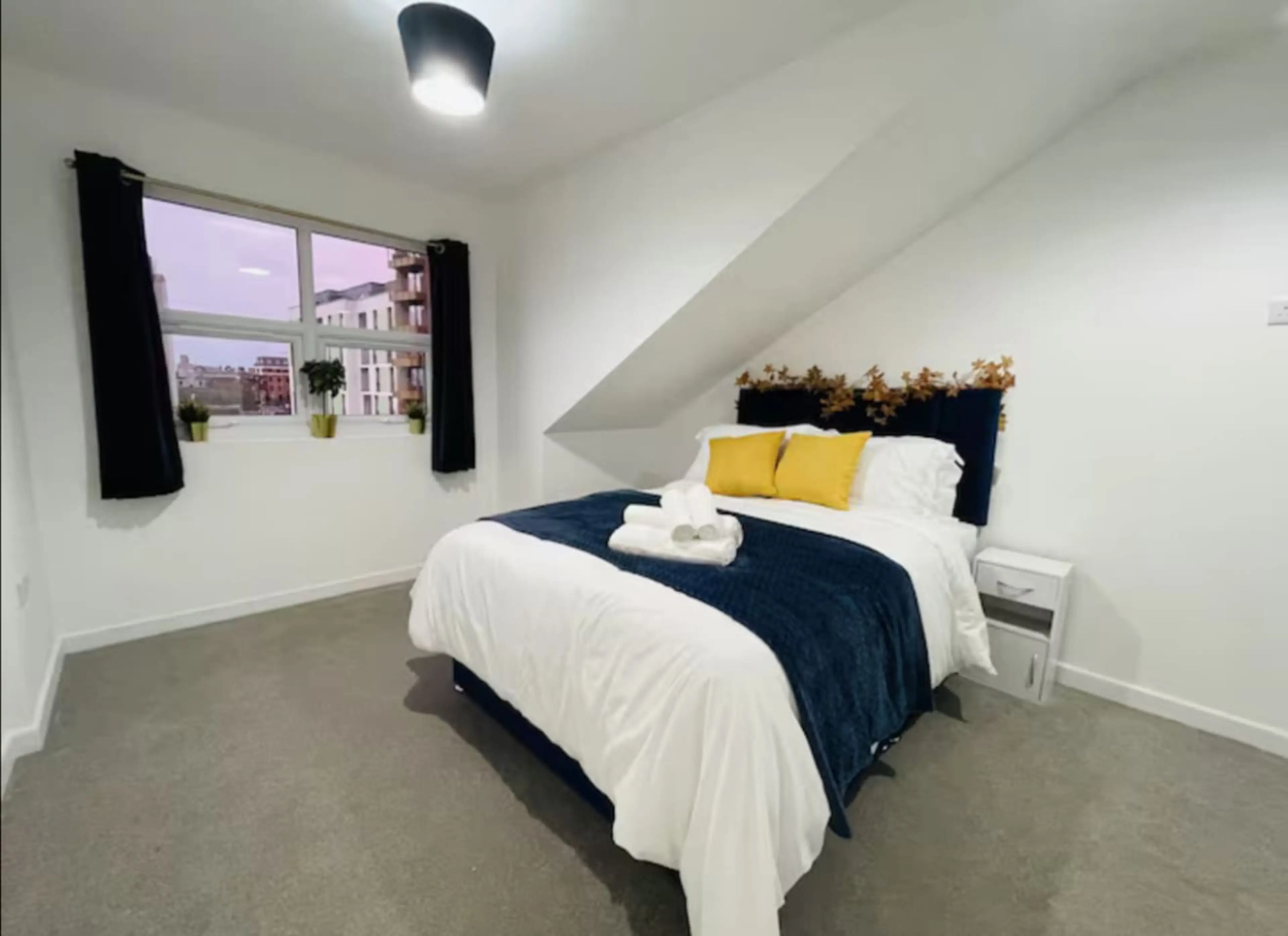 Cozy bed with fresh linens, blackout shades, and storage.