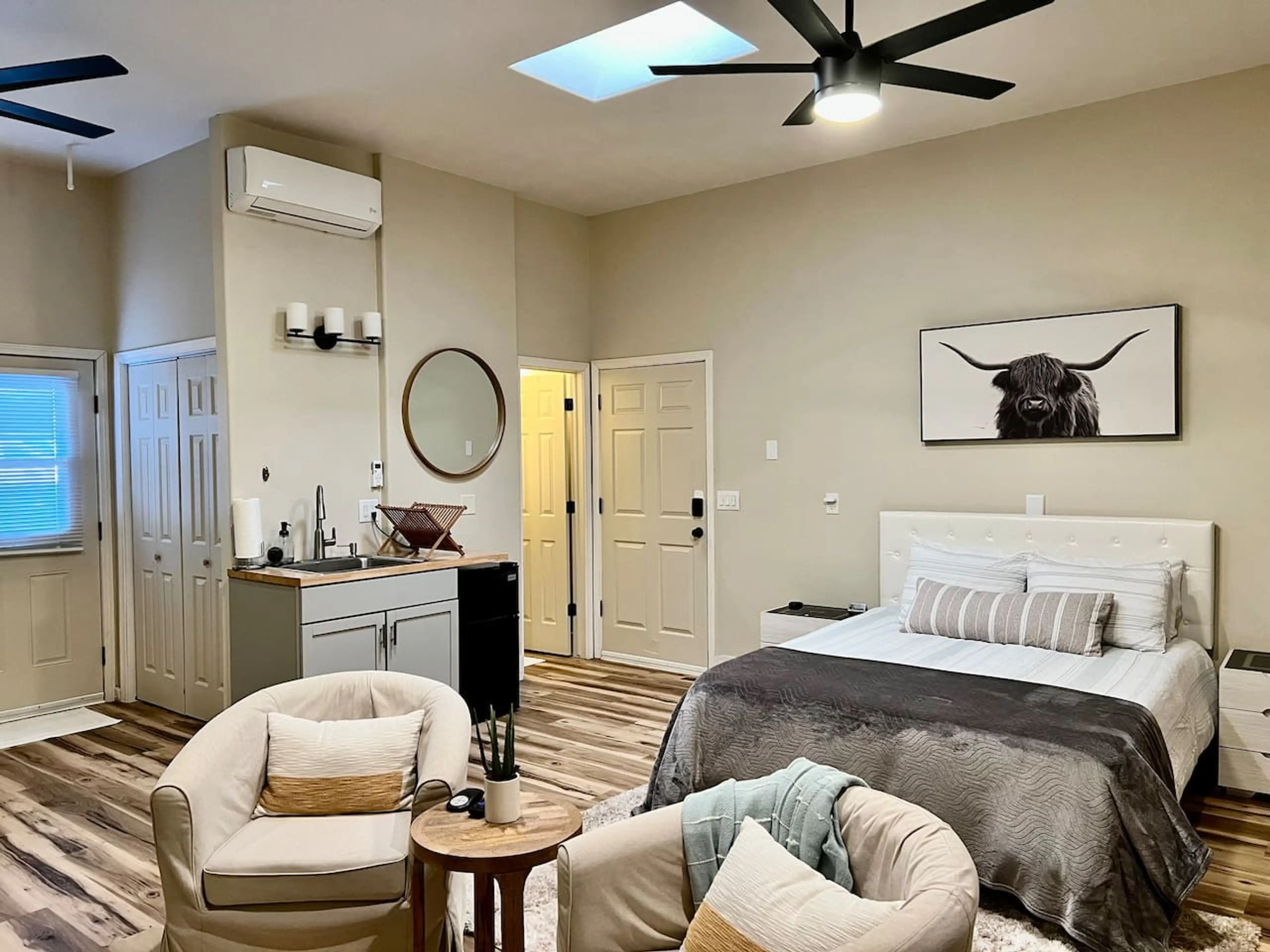 Studio Style - Queen Bed, Seating, Storage Closet, Front Door, Cabinet Space, and Leads to Bathroom