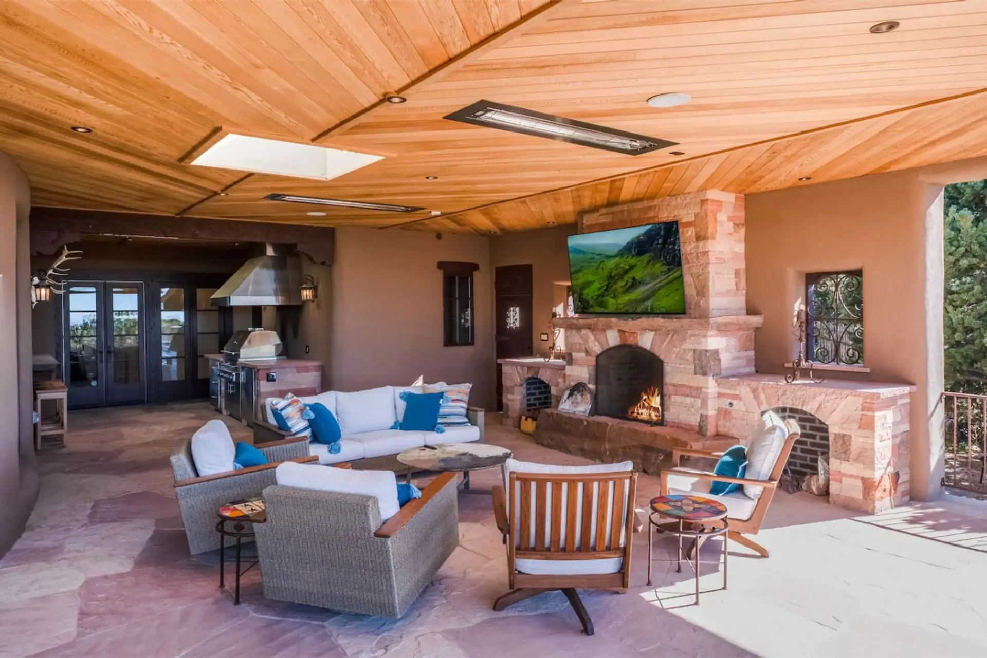 Balcony sitting area with outdoor grill and fireplace.