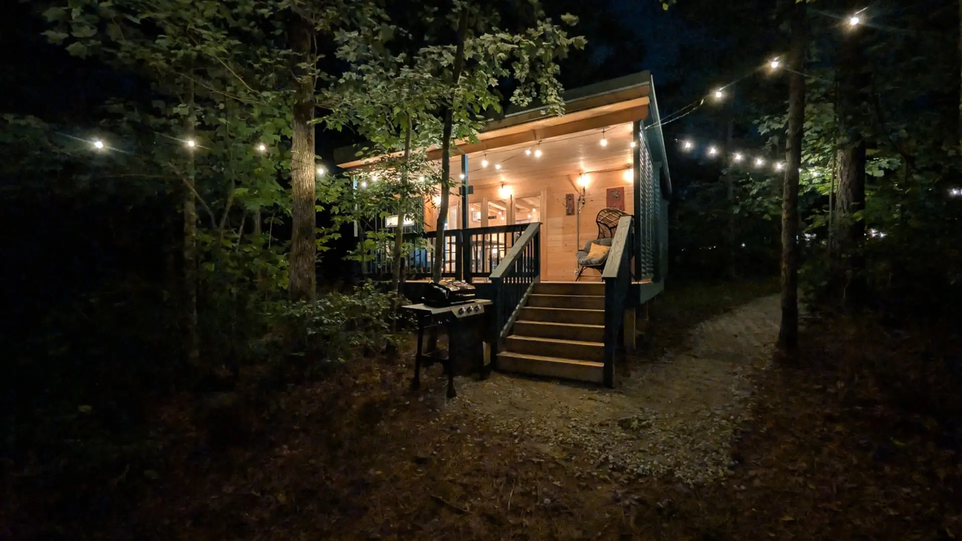 The same exterior at night, porch light glowing.