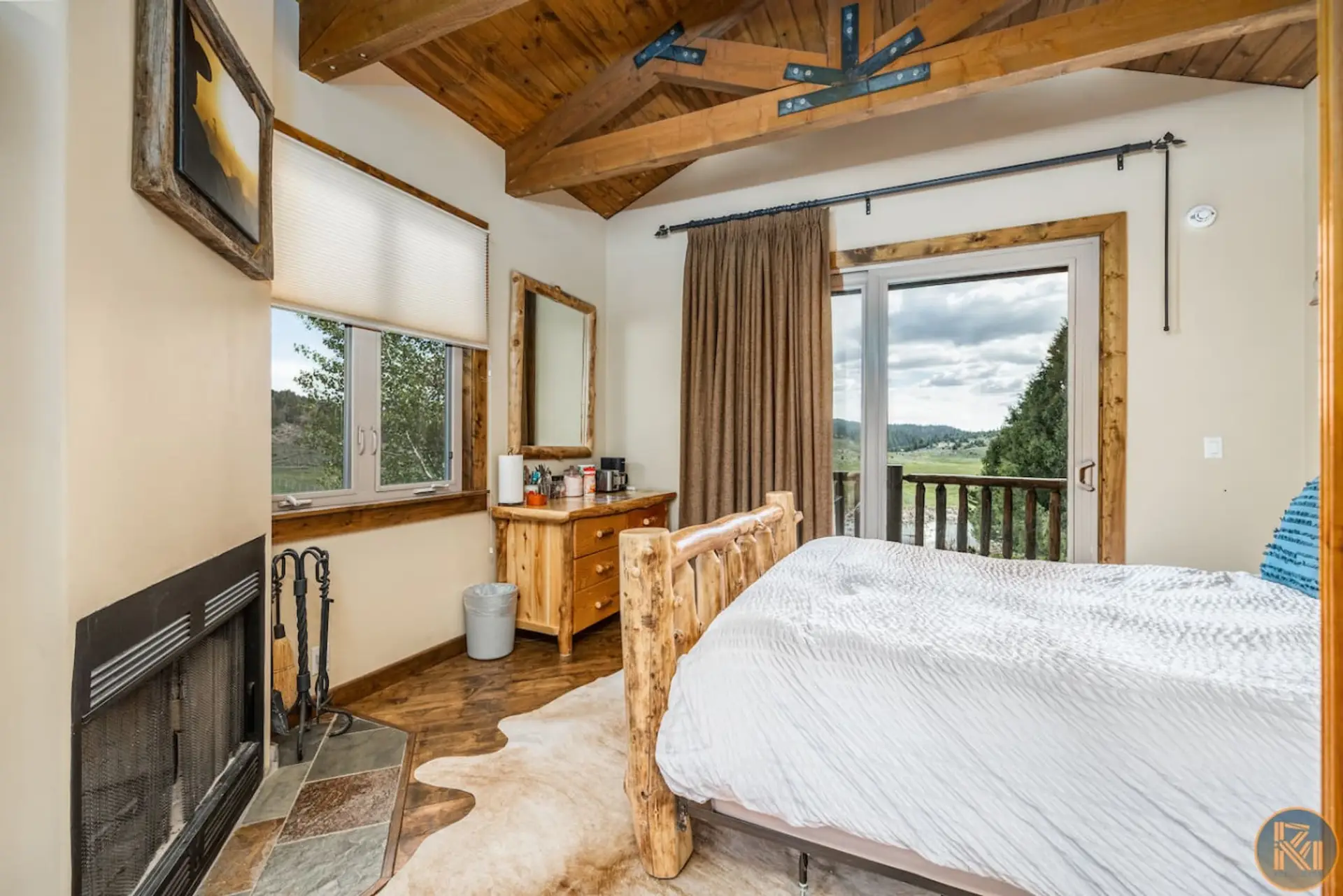 A look inside our luxurious mini cabin featuring a cozy wood-burning fireplace, coffee station, and comfortable queen-size bed — the perfect place to relax after a long day.