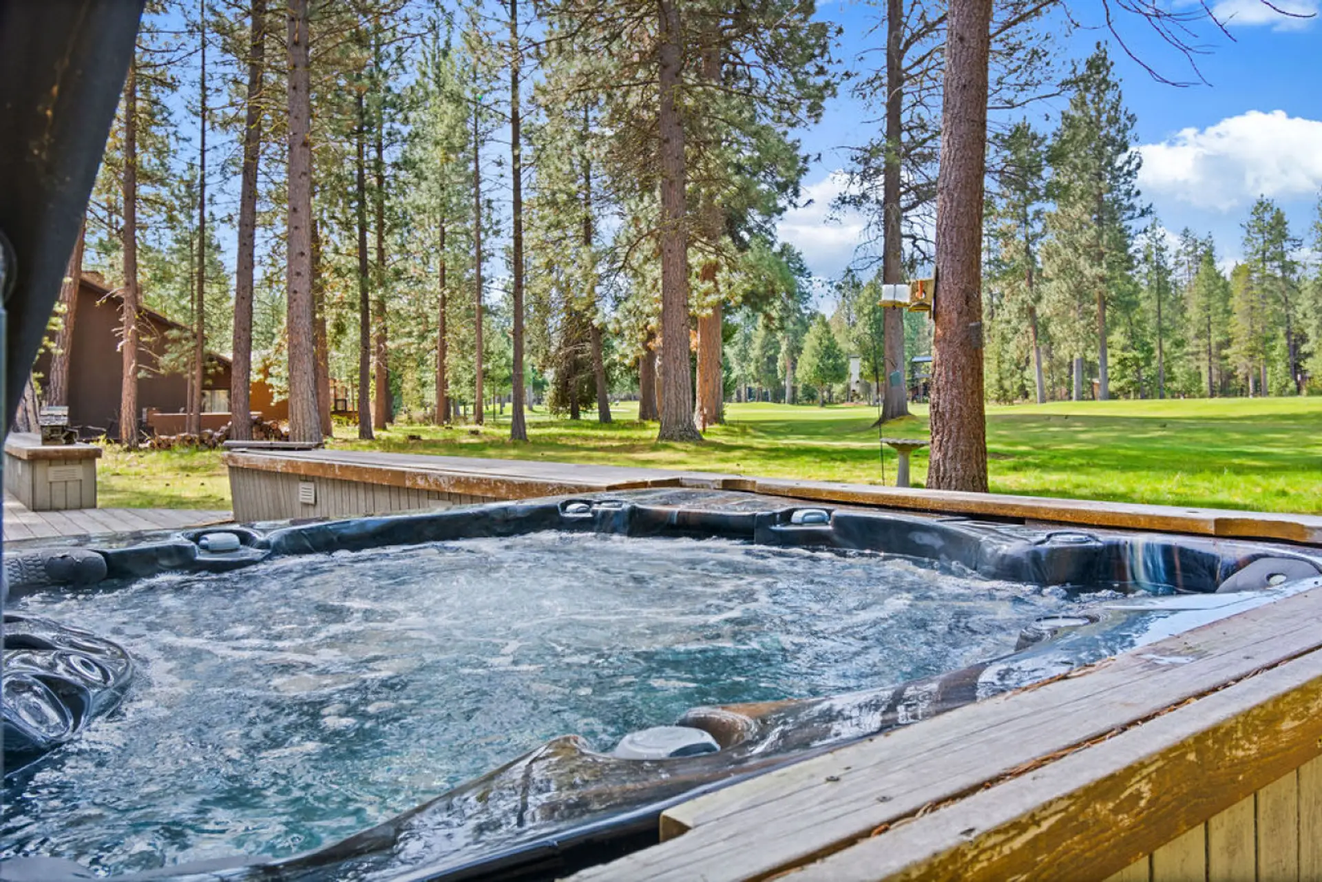 Unwind together in your private hot tub, set along the fairway and surrounded by tall pines.