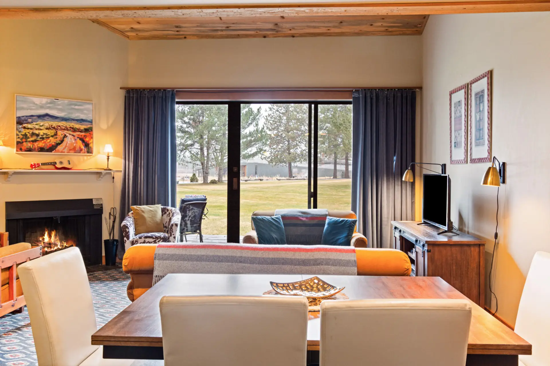 Open living and dining space in Main Condo #32 with fireplace, expandable table, and seating for 8+